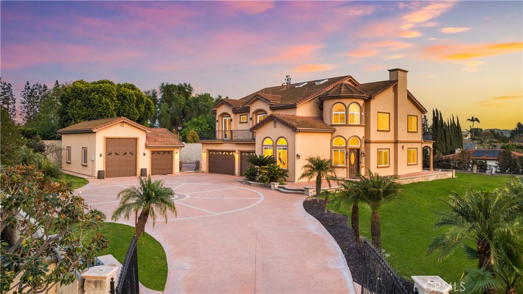 Just a 4-minute drive from the top-rated Yorba Linda High School, this expansive and fully usable 26,632 sqft flat lot is a rare find for athletic families who value both sports and lifestyle quality. Nestled within a private gated enclave, this custom-built estate offers an extraordinary array of recreational amenities including a full-size outdoor NBA basketball court, a private tennis court, and a half-court indoor basketball court inside the oversized RV garage — providing year-round, reservation-free freedom to play, train, and stay active at home. The massive backyard invites endless possibilities: envision a resort-style pool, children’s playground, fruit orchard, or a putting green—there’s space to bring your dream outdoor lifestyle to life. Built in 2007 and meticulously maintained, the home sits on over 0.6 acres of level, premium land. A private electric gate, manicured front yard, and grand driveway create a stately first impression. Inside, you’re welcomed by luxurious hardwood floors, fresh paint, and skylights that fill the home with natural light. A circular foyer and elegant curved staircase lead to soaring vaulted ceilings, enhancing the sense of space and grandeur. The open kitchen boasts custom cabinetry, built-in refrigerator, gas and electric cooktops, quartz countertops, and an oversized center island. The layout flows into the formal dining room and a spacious family room with fireplace—ideal for entertaining or daily living. The home includes 5 bedrooms in total. The upstairs primary suite features a spa-like bath with soaking tub, dual walk-in closets, and a private balcony with views of the city skyline and Disneyland fireworks. A full guest suite on the main floor adds flexibility for multigenerational living or extended stays. Additional highlights include 36 fully paid-off solar panels, a 3-car garage with Tesla charger, a deep garage for a boat, and an oversized RV garage for a 36-foot RV. With No HOA, No Mello-Roos, and low carrying costs, this property delivers the best of luxury, location, and lifestyle. You don’t just own a home—you own a private sports complex and family retreat. The ultimate dream home for the active family—this rare opportunity won’t last. Come see your private sports paradise in person!