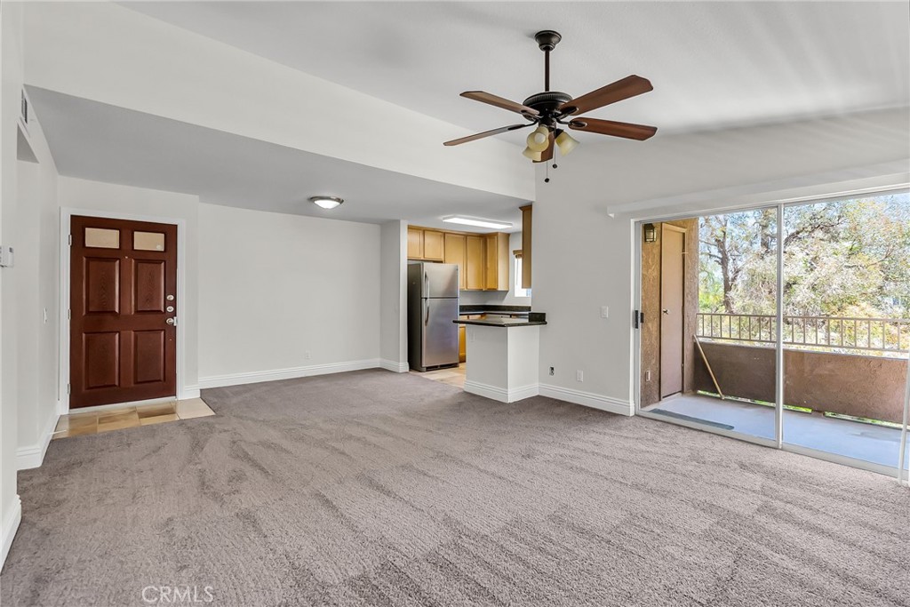 Bright and open with stunning views of the hills and city lights, this top-floor, end-unit condo in Sage Canyon has been freshly updated with new carpet and paint throughout. Step inside to a travertine-tiled entry that flows into the spacious family room, complete with vaulted ceilings, plenty of natural light, and room for all your favorite furnishings. The wraparound balcony extends your living space outdoors, offering a perfect spot to relax and enjoy the views. The upgraded kitchen features granite countertops, stainless steel appliances, and ample cabinet space. The primary bedroom shares the same gorgeous views and includes a roomy walk-in closet. A full bathroom with granite counters, glass shower doors, and ceramic tile ties the home together. In-unit laundry adds extra convenience, and the community offers a sparkling pool for those warm days. Sierra Bella Park is just a short walk away, and you’re only minutes from the 91, 241, and 15 freeways, plus shopping and schools.