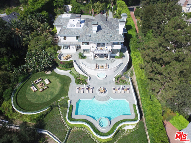 This modern Mediterranean sits on nearly an acre in the exclusive Platinum Triangle enclave known as Lower Perugia Way. One of only a dozen homes that border the Bel Air Country Club, this private compound is set behind gates and manicured palms that lead to a large motor court. A stately entry with a cascading double staircase opens to grand main level interiors such as a formal living room, family area with bar overlooking the famous golf course, formal dining room, wood paneled study, chef's kitchen with Viking appliances and breakfast room. Upstairs holds two generous guest suites, as well as a luxurious master with fireplace, private balcony overlooking the golf course, dual baths and walk-in closets. Pocket doors open to two levels of exceptional, sundrenched terraces with al fresco dining areas and a pool, all facing out to the world-class rolling green course. Features such as putting green and waterfalls complete this incredible opportunity to customize a sprawling estate.