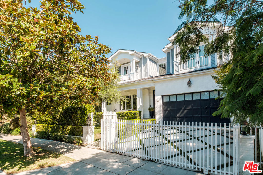 Set within one of Westwood's most coveted neighborhoods, this exquisite custom-built residence blends timeless traditional architecture with modern luxury. Spanning over 5,000 square feet, the home welcomes with warm wood floors, bespoke millwork, and coffered ceilings that exude sophistication and craftsmanship at every turn. The formal living and dining rooms provide convenient access to a wine cellar, creating an ideal space for entertaining. Just beyond, the sunlit family room opens through French doors to a covered stone patio with an exterior fireplace, for effortless indoor-outdoor living. At the heart of the home lies a gourmet chef's kitchen, adorned with striking stone countertops, a seated island, and premium appliances, including a Wolf gas range and double ovens. The space also boasts a full-sized refrigerator and freezer, abundant pantry storage, and a charming breakfast banquette overlooking the backyard. Ascend the curved stairway to the expansive primary suite. This private sanctuary impresses with vaulted ceilings, a balcony, and dual custom walk-in closets. The spa-inspired en suite bath is a serene retreat with dual vanities, dual separate water closets, a glass-enclosed shower, and a luxurious soaking tub. Find three additional bedroom suites upstairs, plus one conveniently located on the main level, providing flexibility for guests or use as an office. Additional amenities include a powder room on the main level, built-in surround sound, and solar panels with three Tesla batteries for sustainable living. Outside, the lush backyard is enveloped by mature hedging and features a covered patio, built-in BBQ, sparkling pool and spa, and a spacious lawn for relaxation or play. Secured behind an automatic driveway gate is an attached two-car garage with newly epoxied floors and direct access. Ideally situated just moments from top-rated schools, Holmby Park, Westfield Century City, and Westwood Village, this remarkable home offers timeless sophistication, comfort, and convenience for the very best of Westside living.