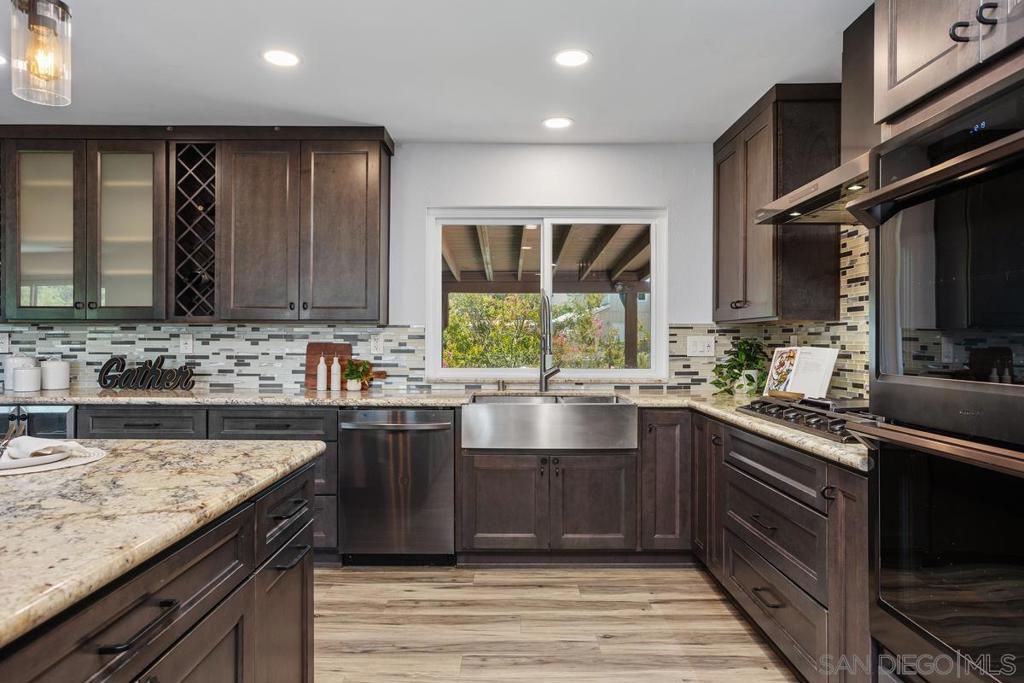 Amazing home on a fully usable one-acre parcel. Sparkling new pool, just completed 6/2025! Custom home features two living areas, perfect for extended family, multigenerational living, or possible ADU. 3,000 gallon well water tank feeds the pool and all landscaping irrigation, owned Solar system, 3 car garage plus a 4 car carport, workshop, and a Greenhouse with Aquaponic system potential. 30+ Fruit trees, plus room for RV, boat parking and horses too! See supplement The upstairs main home features 4 bedrooms, 2 baths, with mountain views and a spacious outdoor deck. Gorgeous remodeled kitchen with custom cabinets, granite counters, double ovens, 5 burner gas cooktop, Wine frig, center island and large eating area. The lower level features 2 bedrooms (one is a den), 1 bathroom, living area, and a full kitchen! Two baths have new shower areas. Large grassy yard plus 30+ mature fruit trees on the property include avocado, citrus, apple, plum, pear, pomegranate, macadamia nut, fig, pear, nectarine, loquat, lemon, pecan, walnut, dragon fruit, naval orange, grapefruit, lime plus blackberry bushes at the perimeter. A great all around property with space and privacy.