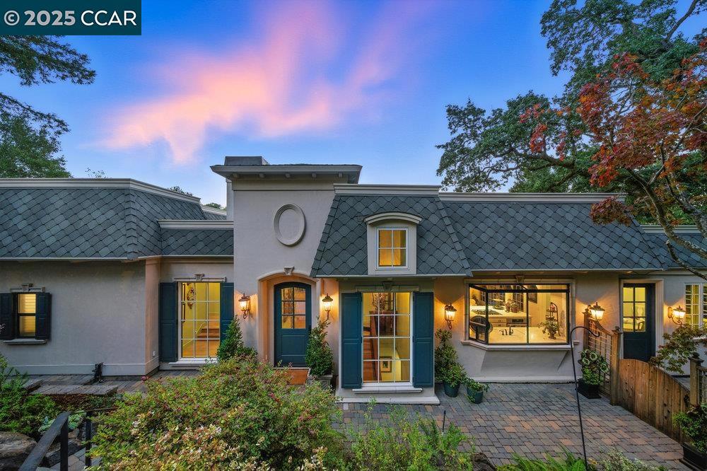 Perched above the 5th Fairway of Orinda Country Club, this stunning French Country home offers sweeping views of the golf course and oak-studded hills. Renovated in 2016, it features soaring ceilings, dormer windows, and walls of glass that fill the home with light and seamlessly blend indoor and outdoor living. The state-of-the-art eat-in kitchen boasts Carrera marble counters, custom cabinetry, a large island, pantry, and charming breakfast room, all opening to a spacious family room and expansive deck. The grand living room is anchored by a dramatic stone fireplace and flows to the elegant dining area, perfect for entertaining. The serene primary suite includes a private office, luxurious bath, and cedar-lined walk-in closet. Downstairs offers three additional bedrooms, one en suite, an updated bath, and a flexible bonus area. With European white oak floors, new roof, beautifully landscaped yard, gas fire pit, and timeless architectural details, this home is a rare Orinda gem. All this charm in a fantastic centrally located location - moments from down town Orinda, Orinda Country Club and all k-12 years of top rated schools. Welcome Home!