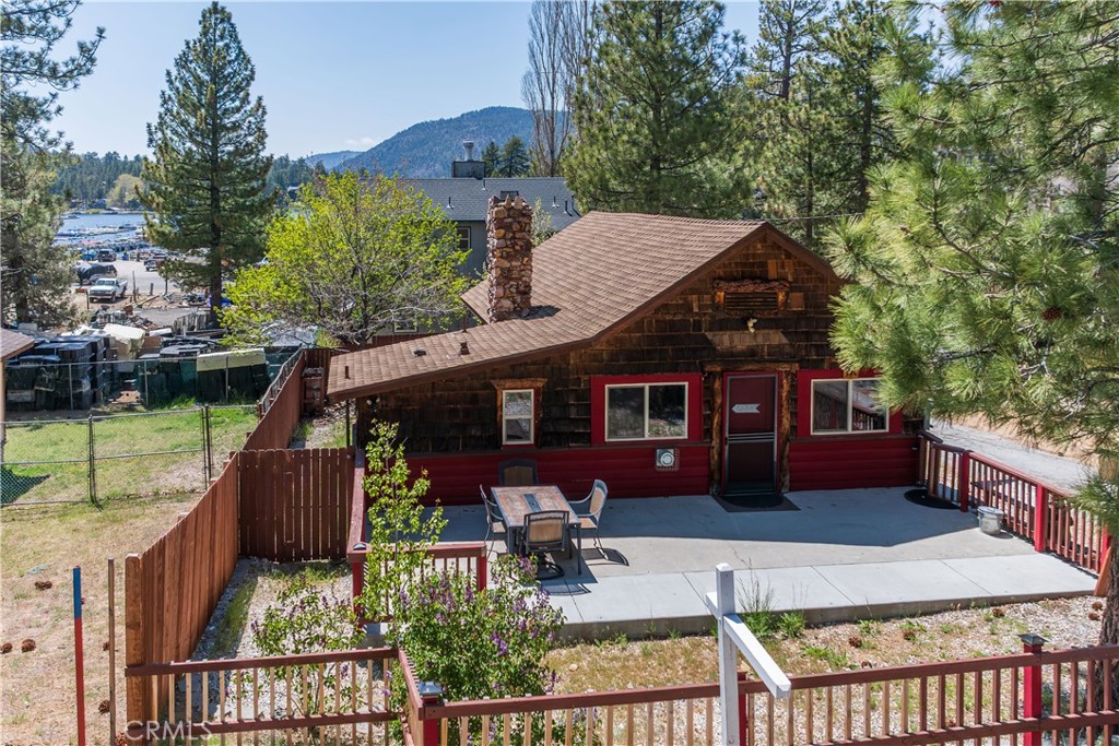 Discover your perfect retreat in the heart of Big Bear Lake, where mountain living meets serene comfort. This charming cabin is your gateway to an idyllic lifestyle, offering a cozy and inviting space with thoughtfully updated features. As you step inside, the cabin welcomes you with its warm and rustic charm, highlighted by a large stone fireplace that promises cozy evenings. The living area features modern flooring that blends seamlessly with the classic cabin aesthetic, while insulated walls and windows ensure a comfortable ambiance throughout the year. Tasteful upgrades have been made to the home, maintaining the rustic allure you seek in a mountain getaway while enhancing its functionality and comfort. Outside, the property delights with its inviting deck that offers peek-a-boo views of the shimmering lake. Whether you're enjoying a morning coffee or a starlit dinner, the outdoor space is perfect for soaking in the natural beauty of Big Bear. The fully fenced backyard provides a private oasis for relaxation and gatherings, framed by a classic picket fence. Located just a stone's throw from Holloway's Marina, you'll enjoy instant access to the lake, making water activities a delightful part of your daily routine. Additionally, the cabin is conveniently close to the village, alpine magic slide, and Gilner Point, ensuring that adventure and amenities are never far away. As one of the best-priced homes in the area, this cabin is a rare find. Embrace the mountain lifestyle and schedule a viewing today to make this charming retreat your very own.
