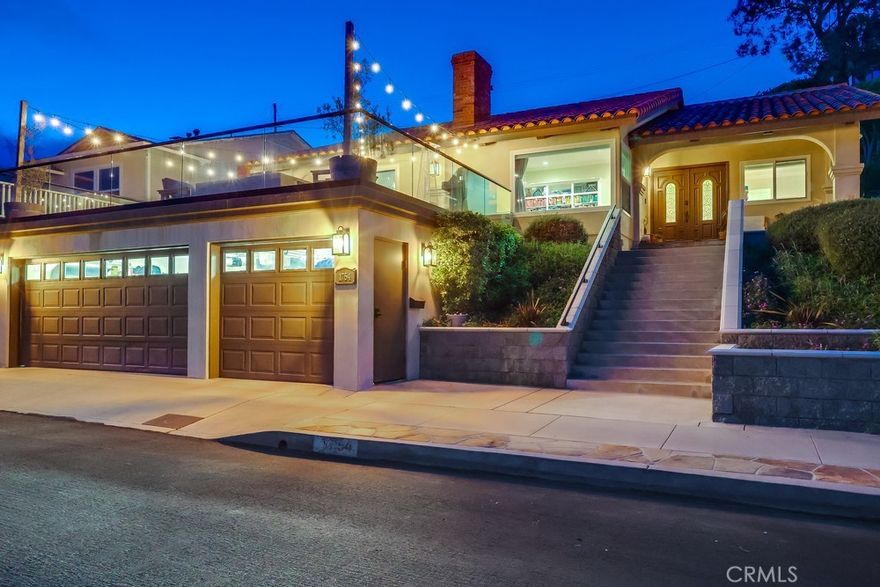 This in not your typical rental home by any stretch. If you are a discerning tenant seeking a refined, low-maintenance coastal lifestyle, this Mediterranean-inspired villa delivers on every level. Nestled on a quiet cul-de-sac in the coveted Upper South Shores, the home enjoys unobstructed ocean and Catalina Island views from nearly every main living space. Cool afternoon breezes complete the relaxed, elevated feel of this special property. Completely reimagined with a focus on quality, this home offers timeless sophistication. It’s not for someone chasing fleeting trends—no stark whites or grays here. Instead, rich natural finishes and craftsmanship take center stage. Designed for those who value elegance and ease over excess outdoor space, this residence is effortless coastal living at its finest. Curb appeal is instant. A wide stone staircase leads through lush, manicured landscaping to a covered front porch trimmed in natural stone. Smooth stucco, a red tile roof, and patina copper accents complete the classic Mediterranean exterior. Through the double-door entry, you’re welcomed by soaring 10-foot ceilings and a large coat closet in the foyer. The formal living room features vaulted ceilings, a natural stone fireplace, built-in bookshelf and a large picture window showcasing panoramic views. An arched opening leads into the formal dining area and the upgraded kitchen, outfitted with custom wood cabinetry, granite countertops, walk-in pantry, and a travertine backsplash. Stainless steel appliances include a six-burner cooktop, counter-depth refrigerator, double oven, dishwasher, and custom hood. The adjacent family room offers a second fireplace, attractive tray ceiling, and sliding glass doors that open to a 600+ sq ft deck. With frameless glass railings and jaw-dropping views, it’s an ideal spot to relax or entertain. The private wing includes a spacious primary suite and two additional bedrooms, all with vaulted ceilings, wide-plank hardwood floors, and generous closets. Both bathrooms feature natural stone, granite, and custom cabinetry. A large indoor laundry room adds ample storage, a utility sink—and even an ocean view. Crown molding, Baldwin hardware, designer lighting, recessed lighting, and a spotless three-car garage complete this truly special home. HOME IS ALSO FOR SALE AT $1,389,000, MLS#SB25161555. ASSUMBALE VA LOAN AT 5.125%