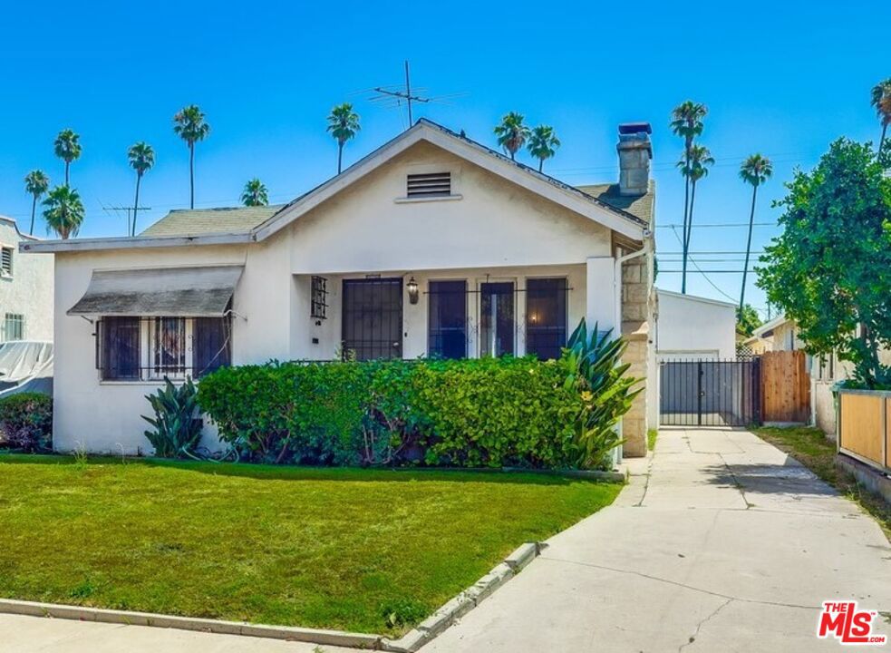 This 1924 Leimert Park gem is bursting with character, charm, and serious upside. Owned by the same family for over 73 years. This 2-bedroom, 2-bath home offers a rare blend of original architectural detail and investment potential. The sunlit living room has classic archways, an Ernest Batchelder tiled fireplace, and new floors that flow into a formal dining room. The kitchen is functional with new stainless steel appliances and a new stove, ready for upgrades to match your vision. One bedroom includes its own ensuite for added privacy, while the spacious primary suite has room to relax or work. A generous backyard with a large deck sets the stage for entertaining, gardening, or future expansion. The detached two-car garage, long driveway, and bonus space work shed offer added versatility ideal for an ADU, studio, or extra storage. Set on a large lot in one of LA's most vibrant and historic neighborhoods, you're minutes from BMO Stadium, the Metro, DTLA, Culver City, and local landmarks like Leimert Park Village. You're just minutes from great local spots like Tak's Coffee Shop, Harun Coffee, Ackee Bamboo, and the popular cafe Highly Likely, all making this a true destination for great food and local flavor. Whether you're restoring it for yourself or reimagining it for strong return, this is a rare opportunity with heart, history, and potential. Don't miss this one before it is gone!!