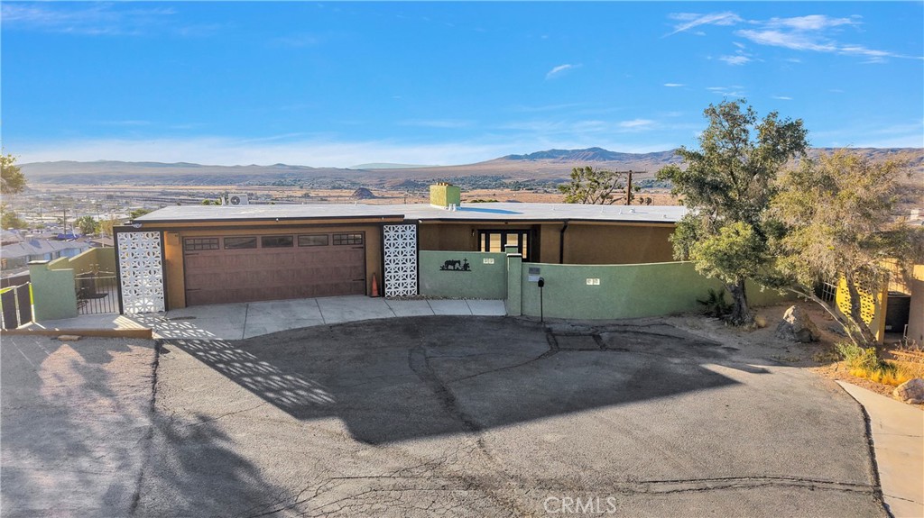 Welcome Home - This One Has "The WOW" Factor! Step into this timeless mid-century charming home where iconic architectural features meet breathtaking views and modern comfort. Located on almost one-of-a-kind location, tucked away at the end of a short, elevated cul-de-sac w/ only a handful of homes surrounding it - offering privacy and limited traffic! As you approach this unique home, you are greeted w/ a spacious, gated courtyard that sets the tone for the luxury and serenity that awaits inside. Upon entry through the custom front doors, you will be captivated by the large living room with its floor-to-ceiling windows framing the desert views that stretch as far as the eye can see - the living room also features a cozy brick fireplace, built ins and access to the incredible wrap around porch! Dazzling lighting and double door access to the wrap around balcony make the elegant, formal dining room as impressive as it is functional! The kitchen is crafted for both culinary artistry & aesthetic delight....sleek cupboards, modern appliances, custom hood range and an entire wall pantry all overlooking another spacious dining space offering picturesque views from the oversized windows! Large primary suite w/ balcony access - you will love the clean lines and two massive windows that meet the open skies - primary bath has a large closet and convenient step in shower! Two great sized guest bedrooms - one has a fireplace, the other has an en-suite bath - all have great views w/ French doors leading to that amazing balcony! Super unique set up in the downstairs level of this home - this versatile space includes a massive great room w/ a wall of windows, its own bathroom, wet bar & wine refrigerator and large storage room....ideal for use as a den, a gym or maybe even the ultimate home office - tons of options! This room also takes full advantage of the panoramic views and affords backyard access. The backyard consists of a low maintenance, fully fenced patio with tons of concrete paving (ideal for entertaining) as well as a section of artificial grass that adds a nice pop next to the mature trees! Indoor laundry, two ac units, two ductless/split ac units, finished 2 car garage and so much more! Take a look today!