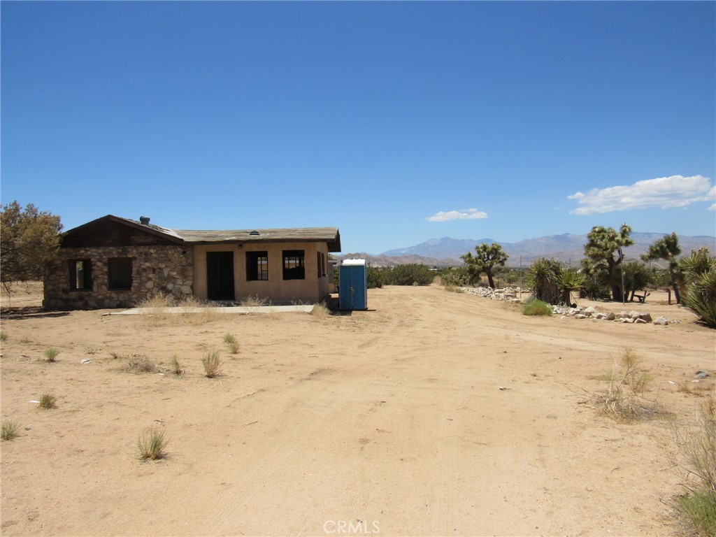 Welcome to the back door into Joshua Tree National Park. This is a 1947 single family residence on 5 acres with amazing views. This home is believed to be one of the older homesteads in the area. The owner has had plans drawn up for the existing footprint that were once approved by the city, but have since expired, showing it is possible to repurpose this property. The plans can be given to the new owner upon closing if so desired. The garage has been wired so that you can utilize a generator for power while working on the property if needed. There is an outdoor shower originally styled out of an old water tank with a view. Also has an on-demand water heater. The water is hauled onto the property as there is no public water source in this area of Yucca Valley for the time being. On the plus side you do not have to worry about needing to be connected to the sewer system at this time. Homes in the area use septic systems. It's less than 10min. from the town of Yucca Valley and just about the same to Joshua Tree. The views of the San Gorgonio Mountain range along with the quiet this property have to offer are an outstanding benefit to owning a property in this area.
