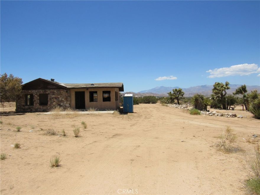 Welcome to the back door into Joshua Tree National Park. This is a 1947 single family residence on 5 acres with amazing views. This home is believed to be one of the older homesteads in the area. The owner has had plans drawn up for the existing footprint that were once approved by the city, but have since expired, showing it is possible to repurpose this property. The plans can be given to the new owner upon closing if so desired. The garage has been wired so that you can utilize a generator for power while working on the property if needed. There is an outdoor shower originally styled out of an old water tank with a view. Also has an on-demand water heater. The water is hauled onto the property as there is no public water source in this area of Yucca Valley for the time being. On the plus side you do not have to worry about needing to be connected to the sewer system at this time. Homes in the area use septic systems. It's less than 10min. from the town of Yucca Valley and just about the same to Joshua Tree. The views of the San Gorgonio Mountain range along with the quiet this property have to offer are an outstanding benefit to owning a property in this area.