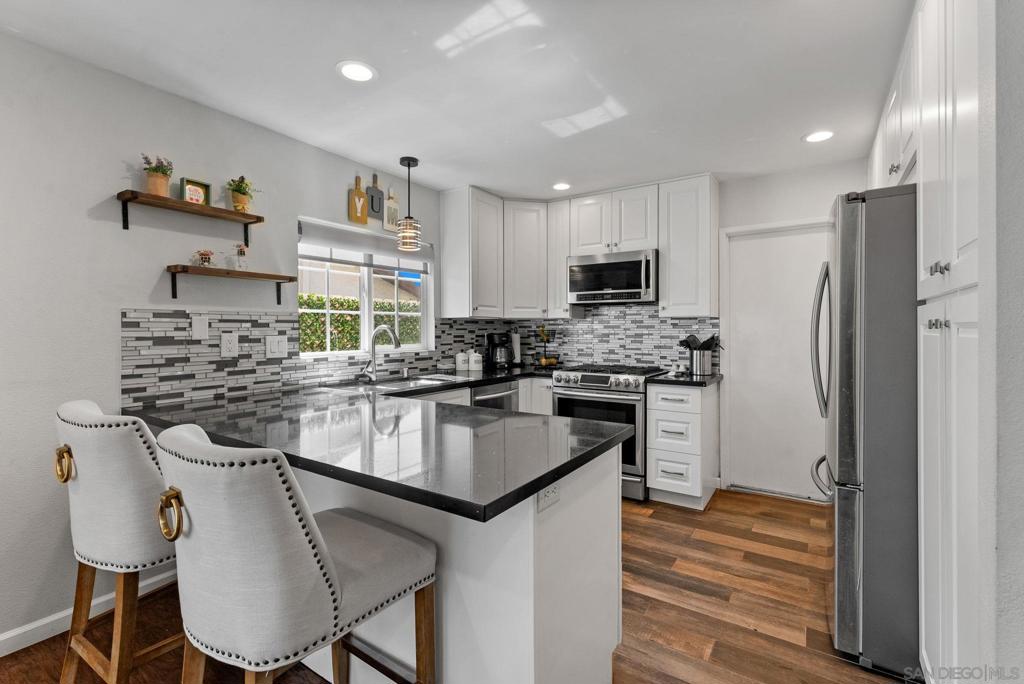 VA/FHA eligible. No HOA. Nestled in one of Santee’s most desirable neighborhoods near Santee Lakes, this beautifully updated home is packed with upgrades. Step inside to soaring ceilings and brand-new laminate flooring that flow seamlessly throughout the home. The heart of the home is the stunning remodeled kitchen, featuring white shaker cabinets, a sleek stainless steel undermount sink, newer stainless steel appliances, quartz countertops, tiled backsplash, and a spacious eat-at bar that opens to the dining area or cozy family room—complete with a fireplace wrapped in black granite. Recessed lighting and dual-pane windows brighten the entire space, while central AC and solar panels provide year-round comfort and efficiency. The newly renovated guest bathroom includes a modern vanity, new mirror, designer lighting, new toilet, and a tastefully tiled tub/shower with updated fixtures. Retreat to the spacious primary bedroom with dual closets, and direct access to the backyard. The en-suite bath offers a large double vanity, new mirror, designer lighting and a separate space for the tub/shower and toilet for added privacy. Enjoy outdoor living in the generous backyard, perfect for entertaining with its covered patio area and room to play or relax. Just a short distance to freeways, schools, parks, sportsplex, YMCA, shopping, restaurants and the beautiful Santee Lakes! Don’t miss your chance to own this upgraded gem in a prime Santee location!