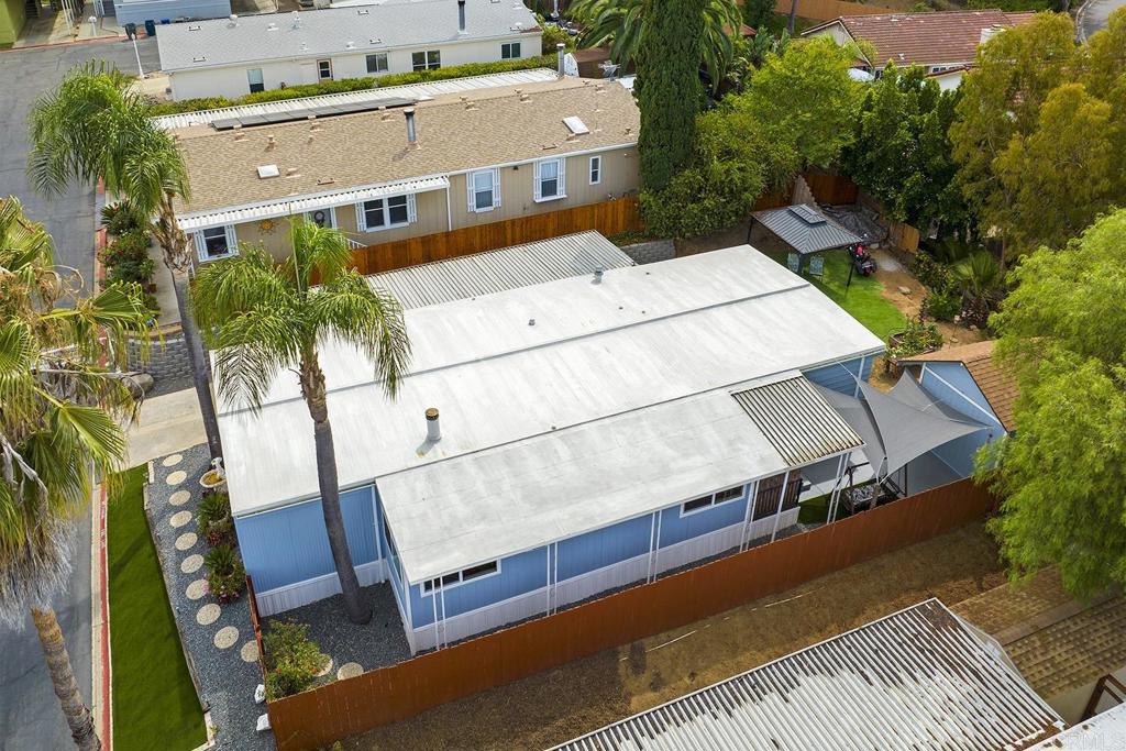 Welcome to this rare ALL-AGE, LAND-OWNED home in the GATED Escondido Views community—no space rent! This beautifully upgraded 4-bedroom, 2-bath home with a bonus room truly has it all—space, upgrades, and lifestyle—in one of Southwest Escondido’s most desirable neighborhoods. Inside, enjoy fresh interior and exterior paint, upgraded flooring, and a remodeled kitchen featuring stunning custom granite countertops, a huge eat-up peninsula, GE stainless steel appliances, and a gas range with griddle—perfect for any home chef. The open-concept layout flows to a spacious living room with a custom built-in entertainment center with an electric fireplace, accommodating up to an 80-inch flat screen. Imagine preparing meals at the peninsula while guests relax by the fireplace! Step outside to impressive curb appeal featuring beautiful landscaping—low-maintenance pavers, pea gravel, turf, and one of the community’s most spacious view lots—ideal for entertaining. The new fence and retaining wall offer privacy, while the upgraded carport with curved supports provide space for up to 5 vehicles. A large 13x15 shed offers plenty of storage or workshop space. Thoughtfully upgraded and maintained with energy-efficient dual-pane windows, regular roof coatings (most recent in August), and newer subflooring and skirting, this home is truly move-in ready. The spacious and functional split floor plan features a private primary suite with two closets and a remodeled bath, along with three secondary bedrooms, a full bath, and a flexible bonus room that can serve as a home office, hobby space, or even a fifth bedroom. For a low HOA of just $268/month, enjoy resort-style amenities: swimming pool, kiddie pool, spa, cabanas, fitness center, clubhouse, game rooms, playground, and basketball court. All this within walking distance of shopping, dining, banking, and just minutes to Lake Hodges, public transit, and major freeways. Part of the acclaimed Escondido Union School District, including Bernardo Elementary, Bear Valley Middle, and San Pasqual High, plus nearby Classical Academy.