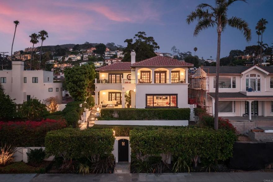 This stunning Monterey Colonial-style home is elevated above the street, offering sweeping panoramic horizon ocean views up the northern coastline. As you step inside, you’ll immediately notice the high ceilings, central staircase, multiple fireplaces, elegant arched doorways, and open floor plan, all complemented by French doors that seamlessly connect the indoors to the outdoors. The tastefully upgraded kitchen, featuring high-end appliances, is paired with an adjacent dining area and family room, creating an ideal space for entertaining. A large living room, framed by expansive windows, showcases breathtaking territorial and ocean vistas. Rich hardwood floors throughout enhance the home’s refined, understated luxury. On the main level, you'll find a thoughtfully designed office/bedroom with custom cabinetry and a fireplace, along with a private bedroom suite, both sharing a private bougainvillea garden view. Pass the laundry room and enter an attached two-car garage with access from Olivet Lane. Upstairs, an additional bedroom and a spacious, luxurious primary suite await. The primary suite features dramatic views with an oversized fireplace and a stylish bathroom with custom walk-in closets. There is no shortage of outdoor space, the primary bedroom offers a private balcony, and a large shared balcony perfect for enjoying the mesmerizing views of La Jolla cove. The sunny backyard is highlighted by a pool and spa, offering a serene space for relaxation, while the front yard boasts covered seating and a turfed play area, all enclosed by privacy gates. The home’s coveted location is within walking distance of the Village and offers easy ingress and egress, making it as convenient as it is desirable. With its upgraded condition, panoramic views, and appealing features, this property is truly one to be seen.