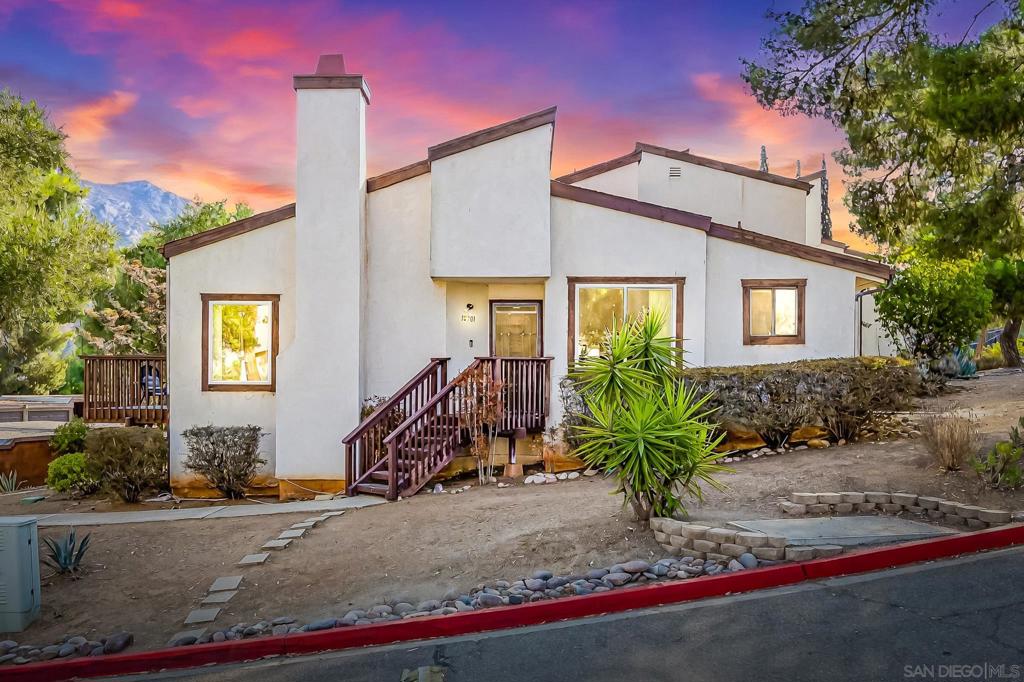 Experience relaxed country living in this charming 2-bed, 2-bath end-unit townhome in San Diego Country Estates. Soak in the mountain views from your private deck, sip morning coffee on the sunny patio, and unwind by the cozy fireplace after a day on the nearby trails or golf course. Vaulted ceilings and an open layout create a light, airy feel, while updated baths, all-new dual-pane windows, a new sliding door, and fresh carpet throughout add comfort and style. Just steps to the pool and surrounded by nature, this home offers the perfect blend of tranquility and convenience.