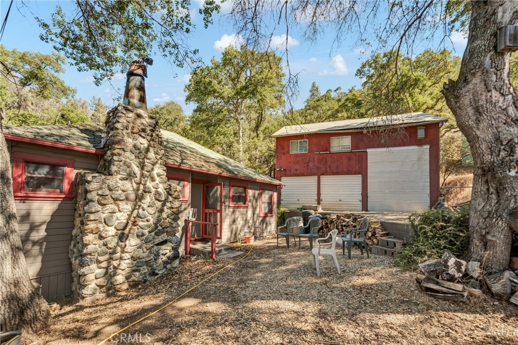 Welcome to this charming 3-bedroom, 1-bath cabin, set on a spacious 13,067 sq. ft. lot. Bursting with character, this home features custom trim and molding throughout, redwood-cased windows, and classic "lawyers wood" walls that add timeless warmth. A striking cobblestone fireplace anchors the living space, while new waterproof laminate flooring provides modern durability with rustic charm.
The property includes a detached garage with both a 1-car bay and a dedicated RV spot, plus convenient boat storage tucked beneath the home—perfect for adventure seekers. Adding to its appeal, this home offers year-round neighborhood beach access, giving you a place to enjoy the lake in every season.