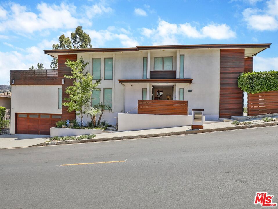 VIEW of City Lights and Canyons. Contemporary home in the heart of Hollywood Hills. This property is ALL About: The VIEW VIEW VIEW! with it's privacy and has large flat yard and multiple large decks. Features 3 bedrooms, 3.5 bathrooms over 3100 living sfqt sits on a double lot of 2.25 arces. Front door lead you to open floor plan: formal dining room, living room with large window with VIEW, Sliding door open to Rare Large Flat wrapped around decks and a large space of lush yard, fruit trees, water fountain. Gourmet kitchen with stainless appliances, center island with bar stools look out windows with VIEW, there is also a large family living room with TV. A guest powder room, Laundry room, few steps down to the Garage. Upstairs features 3 bedrooms all have it's own bathroom. Primary bedroom with large window: wake up with morning sun and looking over DTLA & Canyon VIEW, custom walk in closet, with a set up office area, Primary bathroom with tub and shower. Middle bedroom en-suite. The end bedroom also have it's own large private deck look out with VIEW. Evening with City Lights VIEW. Great for entertaining and A wonderful opportunity to own this sweet home with some of your personal touch to live in Hollywood Hills with amazing view