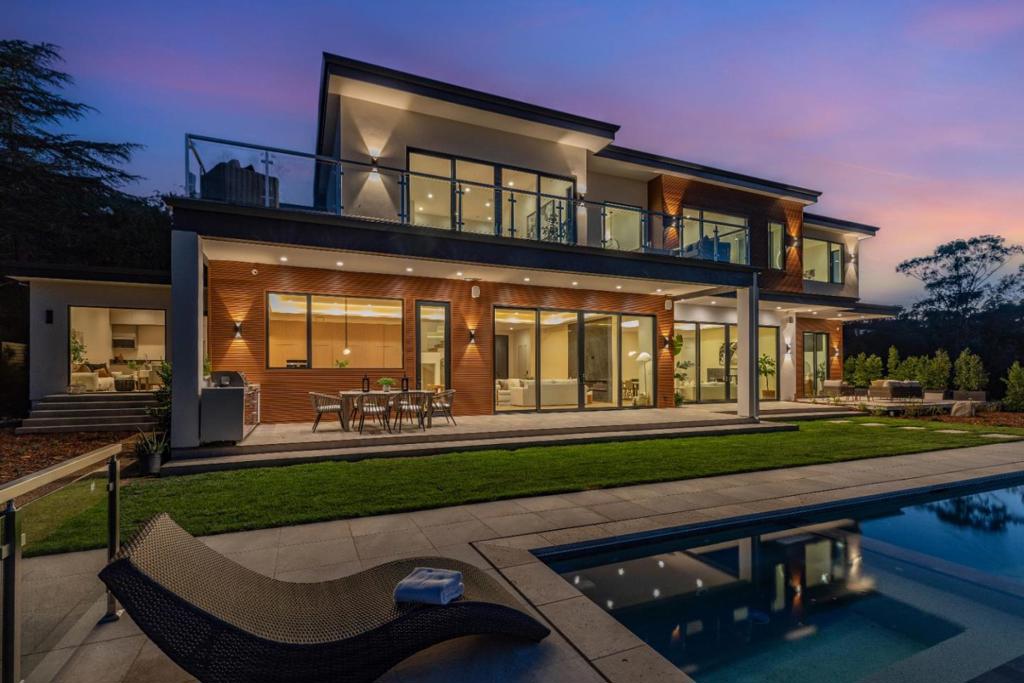 This BRAND NEW (Built in 2024) never-lived-in ECO-FRIENDLY SMART HOME blends modern sophistication with sustainable living, offering breathtaking PANORAMIC VIEWS of the San Francisco Bay. The striking exterior showcases smooth white stucco, warm wood paneling, and expansive glass elements, including a grand entrance and a three-car garage. Soaring tray ceilings, recessed & cove lighting, and floor-to-ceiling sliding glass doors create a bright and inviting atmosphere. The gourmet chef's kitchen boasts sleek cabinetry, luxurious stone countertops, a spacious island, and top-tier Miele® appliances, complemented by a fully equipped butlers pantry. Upstairs, four en-suite bedrooms include a lavish primary suite with a spa-inspired bath and private balcony. The lower level is designed for entertainment, featuring a wine cellar, wet bar, home theater, sauna, & steam shower. The backyard features a patio with an outdoor kitchen and an infinity pool with a pool-level spa. Smart home technology ensures effortless connectivity, while eco-conscious features like solar panels, a heat pump HVAC system, and an ERV air purification system enhance sustainability. A separate two-bedroom ADU adds versatility. This is the ultimate dream home! (Main House: 6,361 SF, ADU: 799 SF, .46 Acre Corner Lot)