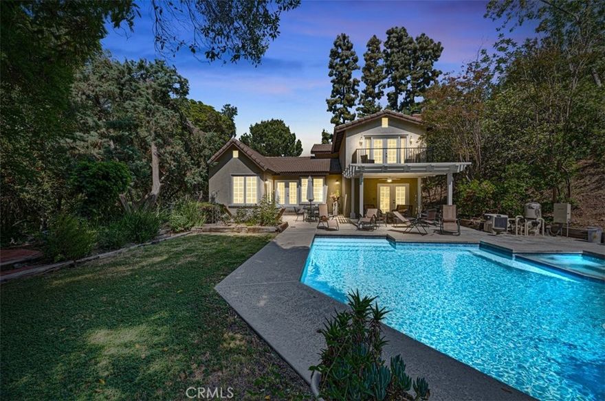 Extraordinarily private estate home situated on a huge lot perched atop a long private driveway at the end of a cul-de-sac in the highly desirable neighborhood of Covina Heights. This home features a pebble-finish pool and spa that were recently remodeled, a huge lot that may be perfect for an attached or detached ADU, and setbacks/elevations that provide maximum privacy.  The interior of the home is bathed in natural light via double French doors with sidelights in the family room, dining room, breakfast nook, downstairs bedroom, and primary suite as well as an abundance of near-floor-to-ceiling windows. The main living area opens up to a newly constructed covered patio with a deck on top that is accessible from the primary suite.  The formal living room adjacent to the foyer may be ideal for use as an office or possible 5th bedroom conversion.  The downstairs bedroom has a separate exterior entrance and direct access to the backyard with a 3/4 bathroom located next to it.  The large step-down family room features a fireplace, wet bar, and direct access to the resort-like backyard complete with extensive hardscaping, manicured lawns, gas firepit, and even its own mini "forest" of trees that adds to the tranquility and utmost privacy of this unique estate home!