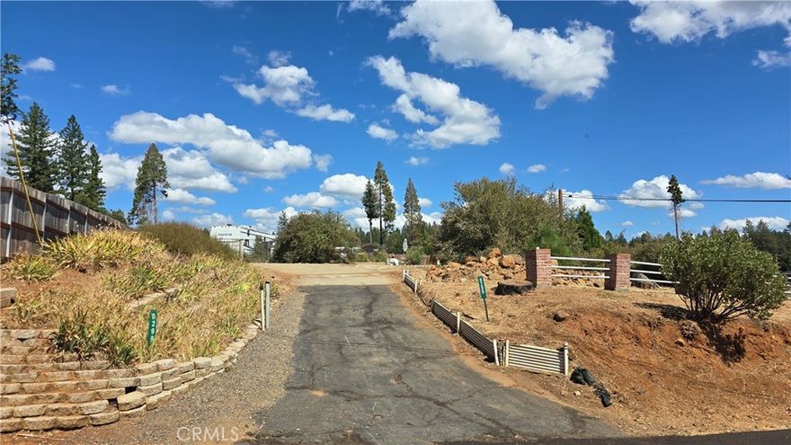 Elevated Corner Lot with Utilities & Mature Landscaping!  This gently elevated corner parcel offers a great opportunity to build your dream home in the heart of Magalia. The lot features existing brick and rail fencing, a partial concrete driveway, and mature landscaping including butterfly bush and other established plants plus raised garden beds still in place.  Power and water are available on the lot, making your building process even easier.  Ideally located just minutes from the clubhouse and only a mile from downtown Magalia, you’ll enjoy quick access to shopping, dining, and the post office. Spend your summer evenings enjoying free live music on the lawn at the nearby Magalia Community Center & Park.  Surrounded by lakes, rivers, hiking and riding trails, this lot is a perfect launching point for year-round outdoor adventure and peaceful mountain living.  It also offers a quick and easy commute via Skyway to both Paradise and Chico. For outdoor enthusiasts, this lot is a short drive from recreational opportunities such as fishing, water sports, and adventure in Paradise Lake, DeSabla Lake, Lake Oroville Marina, or the Feather River. The property's inclusion in the Paradise Pines Property Owners Association enhances its appeal & charm, offering access to amenities such as pickleball and bocce ball courts, a children's playground, hiking trails, a swimming pool and spa, a clubhouse with meeting rooms and a library, dual event centers with fully equipped kitchens, and a bar and lounge for special events and community gatherings. This lot represents the opportunity you've been seeking!