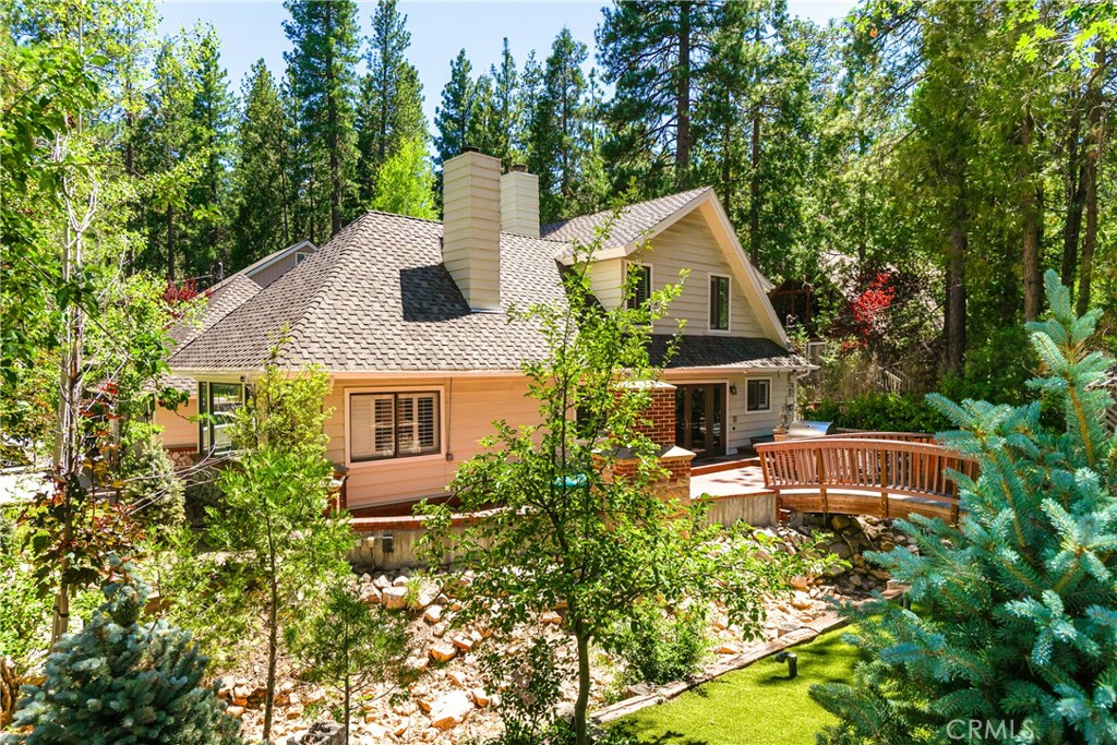 Welcome to Rustic Elegance Retreat, ideally situated in an upscale, tranquil neighborhood on a peaceful cul-de-sac. Enjoy all the perks of living in a prestigious golf course community at less than half the typical cost. Step inside to discover an inviting open-concept design highlighted by beautiful hardwood floors that flow seamlessly throughout the main level.
The recently remodeled kitchen is a dream, featuring stunning white countertops, custom soft-close cabinetry accented with rustic wood details, top-of-the-line Thermador appliances, and a sink perfectly positioned to overlook your meticulously landscaped backyard. Adjacent to the kitchen, you'll find an expansive dining room complete with elegant built-in cabinets, a wet bar, and a convenient beverage refrigerator.
The spacious living room is ideal for family gatherings, comfortably accommodating a large sectional and highlighted by a captivating circular stone fireplace surrounded by abundant windows that flood the space with natural light. However, the true magic lies outdoors. Mature trees frame the property, providing exceptional privacy, while the fully-equipped outdoor kitchen and cozy outdoor fireplace create an entertainer’s paradise. Relax by the natural stream with its charming bridge, gather around the inviting fire pit, or enjoy the fenced side yard outfitted with lush, maintenance-free artificial grass.
The thoughtfully designed mudroom includes a stylish laundry area and convenient attic storage above. The main floor boasts two inviting bedrooms accompanied by a beautifully remodeled, timeless bathroom. Upstairs, you'll find an additional large guest bedroom complete with a private ensuite, and a generously-sized primary suite featuring a comfortable sitting area, an expansive walk-in closet, and a luxuriously remodeled ensuite bath.
Additional amenities include a full-house generator, a top-of-the-line security system with 9 cameras, dual water heaters, and an efficient sprinkler system. This turnkey property not only offers lake rights to Lake Arrowhead but also places you just a short stroll or golf cart ride away from the golf course, making this home a perfect blend of comfort, convenience, and elegance.