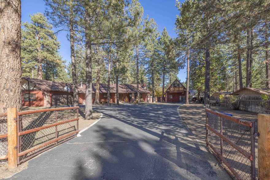 Welcome to your Big Bear getaway! This charming single-level ranch home sits on a roomy half-acre lot surrounded by mountain beauty. Enjoy peaceful mornings on the covered front porch or summer BBQs on the big back deck. The fully fenced yard is perfect for kids and pets to play safely. Inside, you'll find a warm and inviting space that's been lovingly maintained. The primary en-suite is spacious with its own wood burning fireplace and the sliding glass door leads to the redwood hot tub room to enjoy after a day on the slopes or mountain biking. Large living room and separate entertainment room with a bar and game area. The property also includes a separate two-story guest quarters offer excellent flexibility, featuring a full kitchen, bedroom, and bath on the main level, plus a large loft bedroom and additional bath upstairs--ideal for guests, extended family, or rental potential. There's plenty of room for all your toys with a 2-car garage and extra space for RV or boat parking. You'll love the convenient location just off North Shore Drive--close to hiking, biking, and horse trails in Holcomb Valley, and just a short drive to Big Bear Lake, shopping, and the ski resorts, providing easy year-round access.