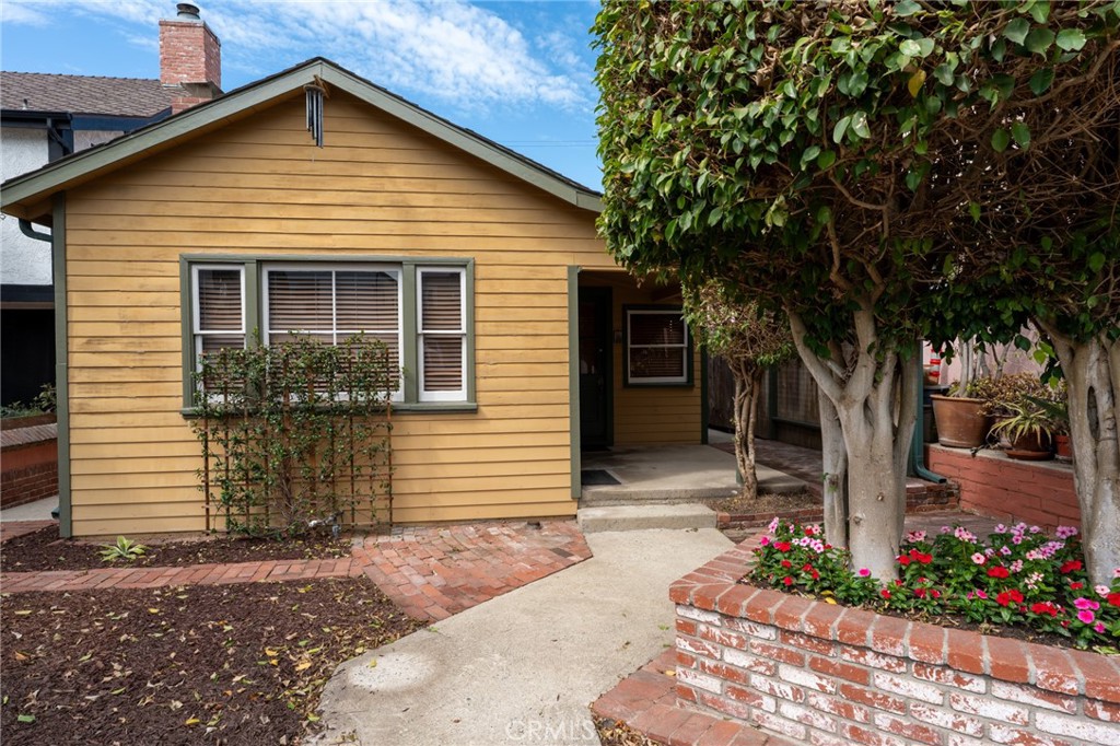 Welcome to a piece of Manhattan Beach history. Nestled on one of the Sand Section’s most coveted streets, this classic 1924 beach bungalow offers a truly rare opportunity. More than a house, this is a beautiful and compelling story waiting for its next chapter to be written.
The story begins on a tranquil, low-traffic cul-de-sac street, on a full street-to-alley lot with a coveted south-facing exposure that bathes the property in warm, California sunlight.
Step inside and be transported to a time of relaxed elegance. The expansive living room welcomes you with its high, open wood beam ceiling and beautifully panelled walls, creating a spacious and airy feel that instantly calms the soul. A charming, brick-faced fireplace anchors the room, promising cozy evenings, while a large picture window frames the peaceful neighborhood outside. Also included is a formal dining room.
For nearly five decades, this home has been cherished by a single owner, a testament to its enduring charm and the immense pride of ownership that it inspires. It's a meticulously maintained retreat ready for its next caretaker.
With a flexible layout, the home is currently a one-bedroom with a den (tax record shows two bedrooms), but it can easily be converted back to a two-bedroom. This home has lots of storage space, including a staircase that leads to a spacious attic...ready for your imagination for future use. The large, sun-drenched front yard is a canvas for your imagination, offering the perfect spot for a vibrant garden or a playful outdoor space.
This location represents the best of the Sand Section lifestyle. Imagine a life where you can leave the car in the garage and walk to everything you need. At one end of the street is the iconic Sand Dune Park, and at the other, the Pacific Ocean—both are just a short walk away.
Just blocks from your doorstep is the North End's vibrant scene, with its unique restaurants, upscale food and beverage store, retail shops, and yoga studios. For families, the distinguished Grandview Elementary is a short stroll down a charming, low-traffic path.
Whether you choose to live in this classic gem as it is, expand its footprint, or build your dream home, the possibilities are endless. There's even a potential for ocean views (BTV) if fully developed, adding another layer to this incredible opportunity.
This is more than a home; it’s the quintessential Manhattan Beach lifestyle experience. Are you ready to continue the story?