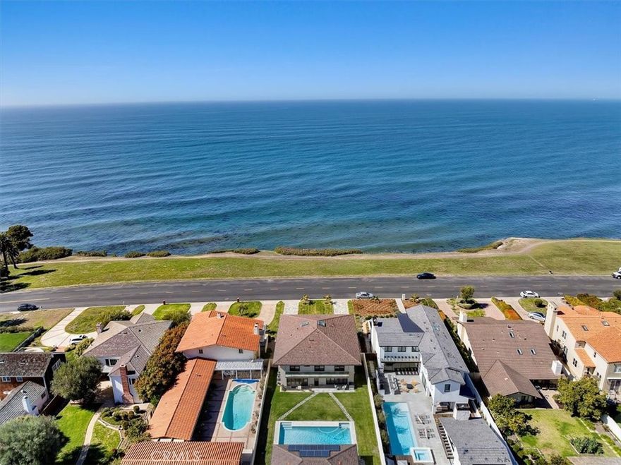 Nestled along the most prestigious street in Palos Verdes Estates, this remarkable residence enjoys an unrivaled location directly across from the bluffs. With protected parkland in front, the home boasts uninterrupted, protected panoramic ocean views stretching from the iconic Queen’s Necklace to Malibu’s Point Dume. The breathtaking scenery also includes vistas of downtown Los Angeles, the Hollywood Sign, Griffith Park Observatory, and mesmerizing city lights that twinkle along the coastline at night.  Spanning approximately 4,300 square feet (buyer to verify), this expansive home features five generously sized bedrooms and six bathrooms. Upstairs, are five spacious bedrooms, with two offering stunning ocean views and access to a spacious balcony and laundry room. The primary suite is complemented by a luxurious en-suite bath, spectacular views, and dressing area. Three additional bedrooms share a second balcony overlooking the backyard and pool area.  The main level is designed for seamless indoor-outdoor living, with large folding style doors that invite the coastal breeze and frame the spectacular ocean views. The open-concept dining area flows effortlessly into the spacious kitchen, family room, a home theater area, and an expansive living room with ocean views provide ample space for entertainment and relaxation. Two half baths serve this level, including one with direct backyard access for convenience when enjoying the pool and outdoor kitchen. The outdoor space is an entertainer’s dream, featuring a large yard, a built-in cooking area, a pool, and spa. Parking is plentiful, with a three-car garage accessible via the back alley and an additional parking pad that accommodates up to five more vehicles. Designed with future possibilities in mind, the home is elevator-ready and offers potential for an ADU. Originally renovated and expanded in 2013, this extraordinary property is a true estate home with breathtaking and highly sought after location.  Close to award wining schools and easy access off the hill to restaurants and shopping.  Owners in Palos Verdes Estates can join the beautiful Palos Verdes Golf Club, Tennis Club, and Swim Club located on the ocean.