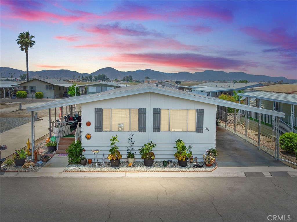 Welcome to your dream retreat nestled in a vibrant community where relaxation meets recreation! This delightful mobile home, featuring two generous primary suites, offers the perfect blend of comfort and style. Measuring 16 x 11 ½ and 16 x 12 respectively, these spacious suites are designed for tranquility and privacy, making them ideal for hosting family or guests. Step inside to discover a world of modern elegance with updated interior and exterior paint within the last year, along with rich laminate wood flooring that flows throughout the main living areas. The open-concept layout is perfect for entertaining, allowing your friends and family to mingle seamlessly from the bright, inviting kitchen to the cozy living spaces. The kitchen boasts a built-in gas range, oven, and dishwasher. You'll find indoor laundry here with appliances included. One of the standout features of this home is the fenced-in dog run, providing a safe haven for your furry friends. Picture evenings spent basking in the warm glow of the sunsets, with cozy gatherings on your oversized porch. The carport accommodates two cars and a golf cart. As a resident of this enchanting 55+ community, you'll have access to an array of amenities designed to elevate your lifestyle. Unwind amidst the picturesque scenery of five shimmering lakes, mesmerizing waterfalls, and beautifully illuminated fountains that create a magical ambiance under the stars. Enjoy the tranquility of a peek-a-boo view of the golf course and serene lakes, all just across the street from your home. This property isn’t just a place to live—it’s a lifestyle waiting to be embraced! Whether you're an avid golfer or simply love to socialize, this home offers it all. With refreshed interiors and an upgraded custom shed with shelves and electricity for extra storage, your new chapter begins here. The Lakes at Hemet West is more than just a community; it's a lifestyle designed to fulfill your dreams. It is resort living at its finest, with a gated entrance and a guard on duty! Enjoy lakes, waterfalls, fishing, golf, pickleball, card games, tennis, dog walks, swimming, gym, etc... Most desires of the heart can be found in this community. Free and available for all residents to enjoy. The Lakes at Hemet West offers frequent social activities, like Taco Tuesday and breakfast burritos at scheduled times for better than early-bird prices. Community events are also on the calendar. Come relax and enjoy the good life.