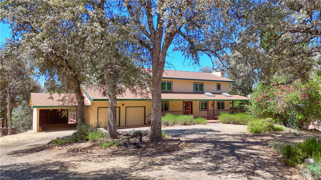 AMAZING CUSTOM HOME with PANORAMIC VIEWS from this private mountain retreat! Just minutes from Yosemite National Park, Bass Lake, and other popular lakes for boating, fishing, house boating, and year-round recreation, this 4-bedroom, 2-bath residence offers 2,760 sq. ft. of inviting living space on 27.54 acres, only a short drive to the historic town of Mariposa.
Step inside to discover beautiful wood-beamed ceilings, wood-encased windows, custom wood flooring, and a stunning river rock fireplace with slate hearth that bring warmth and rustic elegance to the main living area. The spacious kitchen boasts custom cabinetry, stainless steel appliances, and a walk-in pantry, opening to the dining area and expansive wrap-around deck with spa—perfect for entertaining or simply taking in the spectacular views of the gardens, fruit trees, and wide-open skies. A versatile bedroom/office, ¾ bath, and a large laundry room with space for additional appliances complete the first floor. Upstairs features a bright open family/game room showcasing sweeping Sierra mountain views, three additional bedrooms, and a full bath. The oversized primary bedroom provides plenty of space to add a bath, if desired. Additional highlights include a fully paid solar system, private well, attached 2-car garage, several outbuildings plus an additional covered 2-car carport—ideal for a future conversion into a workshop or ADU. Outdoors, enjoy three fenced areas for gardening, pets, or farm animals, along with a detached deck for relaxation or entertaining. A true retreat designed for family and friends—close to Yosemite and Mariposa, yet private and serene with sweeping scenic Sierra Mountain Views. The perfect blend of mountain living, rustic charm, and modern convenience!