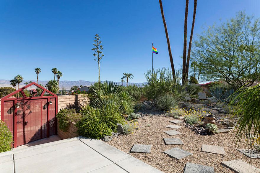Panoramic views and exceptional privacy define this stunning Cathedral City Cove residence, ideally located in the prestigious upper portion of the Cove on a corner lot elevated above the street. The Cove is known for its eclectic building style, proximity to Palm Springs, and affordable prices. This immaculate 3-bedroom Craftsman is the perfect example of what pure magic looks like in this quirky, bohemian community.Once an unremarkable 1970s property, this home has been lovingly transformed over a 20-year period into a warm and inviting Craftsman retreat surrounded by lush, parklike gardens. Though not a style often associated with the desert, the attention to detail and quality craftsmanship has resulted in a rare architectural gem where the classic appeal of a Craftsman blends seamlessly with the breathtaking desert landscape. From its hillside setting, enjoy sweeping mountain views, spectacular sunsets, and twinkling valley city lights below.Designed for entertaining, the home features a spacious living room, a formal dining area, and a large eat-in chef's kitchen with a built-in office nook. Nearly every room offers windows or exterior access to a patio or garden, resulting in a home filled with natural light and inviting seamless indoor-outdoor living. A charming sun porch opens to the sparkling private pool surrounded by plumeria and lush plantings. This sunroom area includes a family room with a fireplace off the primary suite, as well as a second kitchen. Whether you need a kosher kitchen or will simply enjoy the flexibility when entertaining, this feature is a chef's delight.The primary suite includes a walk-in closet and a bright, classic bath with a large shower and even a convenient urinal. Two additional bedrooms look to the front of the home, each offering gorgeous valley views. The corner guest room is en suite, with private access to the adjacent hall bath.Additional highlights include a leased solar system with backup battery installed in 2024, a resurfaced pool with newer equipment, replaced interior plumbing, and a newer HVAC and water heater. The attached two-car garage features a large driveway for ample off-street parking. This home, meticulously maintained as a primary residence, reflects true pride of ownership. It's rare to find such a stunning home of this quality available at such a tremendous price; now is your chance to make it yours.