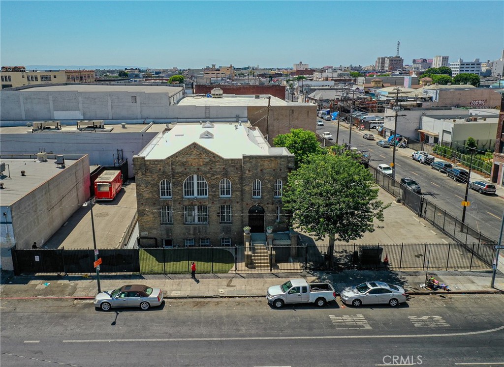 Artist Loft Building with Excess Parking. 9,285 SF Two-Story Building. 13,750 SF Land. 2 Fenced Parking Lots (33+ spaces). Corner Location with 3 Entry Gates. Existing Multi-Unit Artist-In-Residence. Commercial, Residential, and Industrial Uses Allowed. Many Prior Film Shoots. Adjacent to Several Recent Developments.
Property Description: Hard to find multi-unit Artist-In-Residence permitted building with classic red brick construction. Lovely natural lighting via skylights and numerous windows, abundant fenced parking on two sides with 3 gated entrances, hardwood floors, and multiple restrooms with showers. The kitchen and bar include a refrigerator, oven, stovetop, microwave and dishwasher. Remodel as 5 to10 units. Past permit for Artist In Residence use. The 2nd floor is a large open space with natural lighting. Approximately half the size of the first floor, the basement living space has a kitchen and restroom with two stairwells.