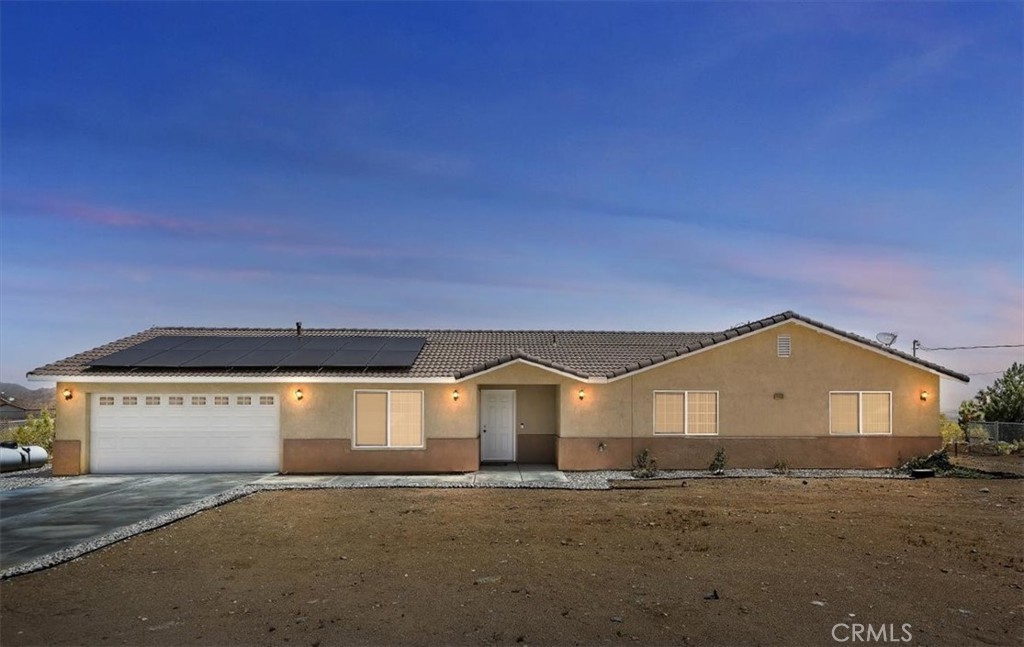 RECENTLY RENOVATED WITH BREATHTAKING UPGRADES, including laminate flooring, elevated baseboards, granite countertops, and newly painted baseboards and cabinets. This expansive open floor plan features a brand-new kitchen equipped with stainless steel appliances. Located just 26 miles from Big Bear, this exceptional opportunity is found in the desirable "Gem Tract," with all access roads leading to your delightful single-story residence being paved. The sunsets and mountain vistas are truly magnificent, and on occasion, you may even witness some snowfall. Each bedroom is remarkably spacious, particularly the primary bedroom, which is enormous, complete with ceiling fans and newer carpeting. Both bathrooms are outfitted with dual vanity sinks and freshly painted cabinets. The large living room boasts a cozy fireplace and seamlessly integrates with the kitchen and family room. Spanning over half an acre and offering ample gated RV parking, the possibilities are endless. Seize this opportunity now, as it will not last long.