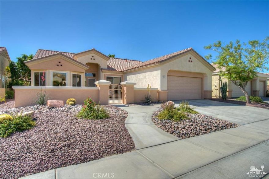 Sun City Palm Desert - St. Croix. South facing, great curb appeal, gated courtyard w/lovely desert friendly landscaping & artfully designed artificial turf front & back. Located close to Sunset View Clubhouse, restaurant & pool, this popular greatroom plan was tastefully remodeled last year, with most new Milgard windows, 20 inch diagonally laid tile & 5 inch baseboards throughout. Graceful living room fan and window treatments added w/custom cornice boxes. Double fireplace w/stacked stone facade sits between greatroom & master suite, with den off greatroom. Kitchen w/dining nook, rollout shelves, breakfast bar, wall oven & microwave. Nearly all appliances replaced including washer and dryer. Large master suite has walk in closet w/built-ins. Master bath has dual sinks, oversize tub & separate walk in shower w/custom tile. Laundry room w/added storage. Two car garage w/epoxy floor & additional storage.
