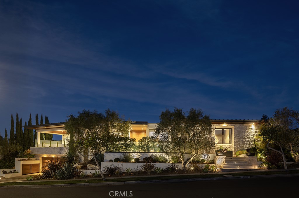 Located in the prestigious beachside community of Cameo Shores in Corona del Mar, this impressive residence presents nearly 6,000 sf of single level living, plus 900 sf of lower level entertaining space on an elevated parcel of over 12,000 square feet. Behind the gated entry, reveals a warm and welcoming floor plan complemented by a private outdoor oasis with a sparkling pool, relaxing spa, firepit and several seating and dining vignettes. The abundance of space is felt throughout the residence, with voluminous ceilings and natural light permeating through walls of glass. Ocean views are experienced and enjoyed by the south-facing patio and adjacent living and dining rooms. The culinary kitchen with a fifteen-foot island is a central gathering space for the home, harmonizing living, dining and outdoor spaces. A secondary kitchen & bar provide convenient service to the central pool space, while an ideally placed media room with bi-fold doors extends the indoors to outdoors. Interior finishes are elegant while providing a subtle palette of textures. Solid wood flooring anchors the natural stone countertops, custom wall coverings accent the cabinetry, sophisticated lighting, and automated window shades & curtains functionally finish ease of living. The home is equipped with full home automation by Control4 which manages lighting, audio/visual, heating & air, shades and security. The main level primary suite encompasses an entire wing of the home, starting with an executive office. Just beyond is the spacious primary bedroom with fireplace, additional seating and private access to the pool and spa is discovered. Dual vanities, custom cabinetry, a stone & glass shower, and tub thoughtfully detail this tranquil space. A perfect finale to the primary suite is a closet featuring a center island with dual-sided drawers and enclosed wardrobes. The functionality of this home is further exemplified with four-bedroom suites and two powder bathrooms. Additionally, enjoy a subterranean level with a 4-car garage, wine cellar, full bathroom, and a state-of-the-art movie theater with entertaining bar. A rarely found rooftop deck is a rare perk in Cameo Shores, offering breathtaking panoramic ocean views. Cameo Shores affords gated beach access to three neighborhood beaches and Crystal Cove State Beach, along with a short stroll to countless amenities, shops and restaurants along PCH.