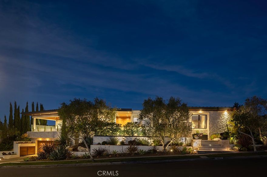 Located in the prestigious beachside community of Cameo Shores in Corona del Mar, this impressive residence presents nearly 6,000 sf of single level living, plus 900 sf of lower level entertaining space on an elevated parcel of over 12,000 square feet. Behind the gated entry, reveals a warm and welcoming floor plan complemented by a private outdoor oasis with a sparkling pool, relaxing spa, firepit and several seating and dining vignettes. The abundance of space is felt throughout the residence, with voluminous ceilings and natural light permeating through walls of glass. Ocean views are experienced and enjoyed by the south-facing patio and adjacent living and dining rooms. The culinary kitchen with a fifteen-foot island is a central gathering space for the home, harmonizing living, dining and outdoor spaces. A secondary kitchen & bar provide convenient service to the central pool space, while an ideally placed media room with bi-fold doors extends the indoors to outdoors.  Interior finishes are elegant while providing a subtle palette of textures. Solid wood flooring anchors the natural stone countertops, custom wall coverings accent the cabinetry, sophisticated lighting, and automated window shades & curtains functionally finish ease of living. The home is equipped with full home automation by Control4 which manages lighting, audio/visual, heating & air, shades and security.  The main level primary suite encompasses an entire wing of the home, starting with an executive office. Just beyond is the spacious primary bedroom with fireplace, additional seating and private access to the pool and spa is discovered. Dual vanities, custom cabinetry, a stone & glass shower, and tub thoughtfully detail this tranquil space. A perfect finale to the primary suite is a closet featuring a center island with dual-sided drawers and enclosed wardrobes.  The functionality of this home is further exemplified with four-bedroom suites and two powder bathrooms. Additionally, enjoy a subterranean level with a 4-car garage, wine cellar, full bathroom, and a state-of-the-art movie theater with entertaining bar. A rarely found rooftop deck is a rare perk in Cameo Shores, offering breathtaking panoramic ocean views.  Cameo Shores affords gated beach access to three neighborhood beaches and Crystal Cove State Beach, along with a short stroll to countless amenities, shops and restaurants along PCH.  Property can be delivered fully furnished for an additional offering.