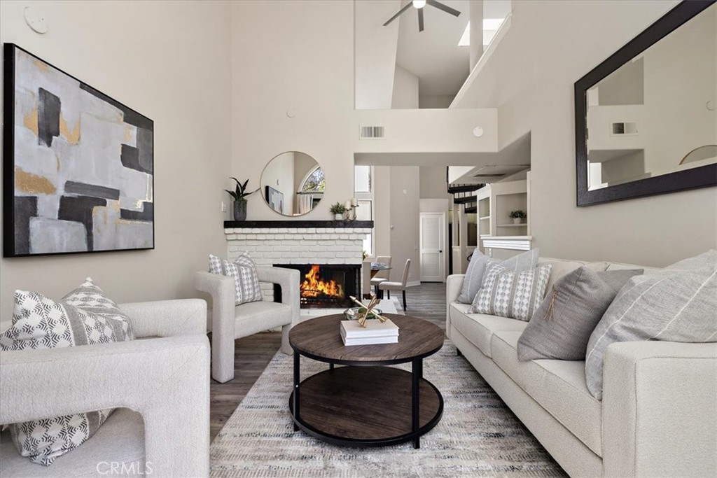 Tucked into lush, tropical landscaping, this beach-close home offers the perfect blend of style and serenity. Soaring ceilings, floor-to-ceiling windows, and a skylight flood the space with natural light. Custom built-ins, bullnose corners, detailed molding, and a beautiful spiral staircase add architectural charm, while a sunny private patio feels like your own treehouse escape. The updated kitchen features timeless white quartz countertops, classic subway tile, and stainless steel appliances. Luxury vinyl plank flooring flows through the main living areas, complementing soft carpet in the loft and on the stairs. The spacious primary suite includes an ensuite bath, and the versatile loft makes an ideal second bedroom or home office. Additional highlights include in-unit laundry, a cozy fireplace, new ceiling fans, and reserved parking. Located in the gated Cabo del Mar community just steps from the Bolsa Chica Wetlands and minutes to the beach, dining, and shopping. Enjoy resort-style amenities including a pool, spa, sauna, tennis and racquetball courts, clubhouse, and greenbelts. This one has it all—don’t miss it!