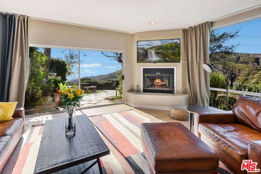 Showings will be Thursdays and Saturdays (during the day only) by appointment only. Just minutes away from some of Malibu's most prized beaches, this three bedroom, three and a half bath coastal canyon residence offers breathtaking ocean and mountain views in a coveted, countryside setting. Views and vibes permeate the home as do the gentle sound of waves in the morning and golden sunset hues at dusk. The stairs leading up to the house wind through a beautifully landscaped garden, creating a sense of peace and tranquility as you make your approach. The entry hallway accented with art niches and views of the rear garden welcomes you. The newly installed wood flooring adds a touch of modern elegance, as you journey through the home to explore your canyon retreat. The recently refreshed and nicely equipped kitchen with breakfast bar invites you to show off your culinary talents and serve up memories and meals in the adjacent dining area. From there, sliding glass doors deliver you to a sprawling deck, ideal for hosting sunset soirees or enjoying quiet evenings under the stars. The rear of the home is also easily accessed from the kitchen through an office nook leading to the fenced garden area perfect for pets. The main level of the home also features a light-filled living room, with a cozy fireplace and desk alcove, where sunset and mountain views stream in through the picture window. Sliding glass doors off the living room open to a beautiful side yard with multiple seating areas, a spa and forever views. One level up, the primary bedroom suite is a true sanctuary featuring a fireplace, walk-in closet, and large primary bath including a soaking tub overlooking the ocean. The primary bedroom boasts spectacular ocean and mountain views framed cinematically through a huge picture window on one wall and a large glass slider on the other. The balcony is sublimely situated for viewing sunsets over the Pacific. The lower level of the home, which includes the laundry room, provides two additional spacious bedrooms with stunning mountain views. There is direct access to the home from the garage. Whether you prefer an adventurous hike, a scenic cycle or a relaxing beach day, this home provides the best of mountain and coastal living. Contact us today to schedule a private tour and experience the magic of this Latigo Canyon gem for yourself.