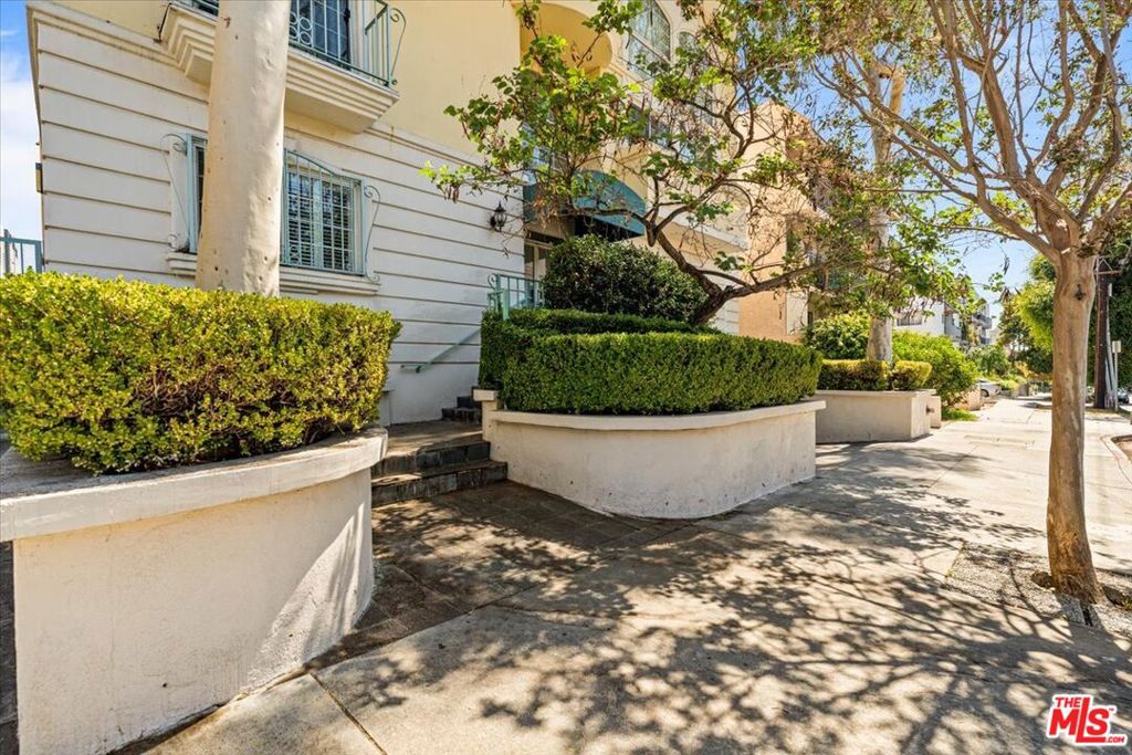 Discover an incredible opportunity to own a beautifully designed 2-bedroom, 2-bathroom condo perfectly situated near the heart of West Hollywood. This thoughtfully crafted residence offers the ideal blend of modern comfort and urban convenience, set in one of LA's most desirable areas. Step inside to find gorgeous hardwood floors flowing throughout the open-concept living space. A cozy corner gas fireplace adds warmth and charm to the spacious living/dining area, while elegant plantation shutters provide a touch of timeless sophistication. Whether entertaining or enjoying a quiet evening at home, this layout is designed for versatility and comfort. The two bedrooms are positioned on opposite sides of the unit for optimal privacy, each featuring a generous walk-in closet and an en-suite bathroom. The galley-style kitchen is both stylish and functional, offering modern appliances, ample counter space, and a convenient breakfast bar perfect for casual dining or serving guests. A dedicated closet off the kitchen houses a stackable washer/dryer, enhancing everyday ease. For year-round comfort, the home is equipped with central heating and air conditioning. Two subterranean side-by-side parking spaces add convenience - an invaluable feature in this bustling neighborhood. Residents also have access to a communal rooftop deck with a spa, where breathtaking 360-degree views of the city set the stage for relaxing evenings or lively gatherings under the stars. Located just minutes from West Hollywood's trendy restaurants, boutiques, and entertainment hot spots, this home offers an unbeatable combination of tranquility and accessibility. With easy access to major transportation routes, you're perfectly positioned to enjoy the best of LA living. Don't miss this incredible opportunity - schedule your private showing today!