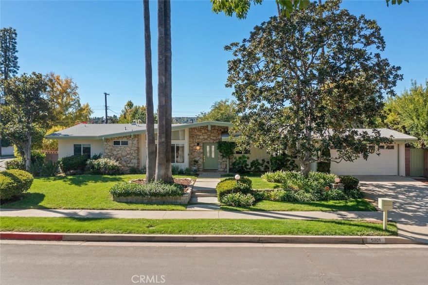 Introducing a vibrant single level mid-century modern pool home designed by renowned architect Charles Du Bois that has been curated to truly stand out from the crowd. Combining authentic materials, inspiring colors, and modern amenities, this one story stunner is bursting with character and intelligent functionality. The property is located on a sweeping corner lot with rolling front lawns, natural stone cladded exterior, and entry pathway flanked by towering Palms and a gorgeous full growth Magnolia tree. Step into a spacious entry foyer featuring a convenient guest powder bathroom, beautiful two-tone cork flooring, and walls adorned with a hand painted cloud motif. The entry opens to separate large living & family rooms each with tongue & groove wood beamed vaulted ceilings, redone double sided brick fireplaces, one with an original 60’s brass cover, & two sets of glass sliders that open to the backyard for the perfect indoor/outdoor flow. The family room also features custom built-in storage cabinetry and a separate dining nook with wood product wall and one of many designer lighting fixtures found throughout. The just remodeled kitchen opens to the family room and boasts stainless appliances, soft close cabinetry, quartz counters, pantry storage, porcelain tile, original 60’s pendant light, and breakfast nook. The primary bedroom overlooks the backyard and features closets with custom built-ins and a spectacular en-suite bathroom with dual sinks, custom glazed countertops created by Bali artisans, walk-in steam shower with rain shower head and striped tile design, bezel set glass vanity lighting, and Kohler luxury line polished nickel fixtures & toilet. The secondary bedrooms are each well appointed with oversized picture windows. A shared bathroom has floating vanity with dual sinks, shower with tub, chrome finishes, and custom glass & ceramic tile. The entertainer’s private backyard features swimming pool with new filter, sprawling grass lawn for play, covered patio for outdoor leisure & dining, and new landscaping with updated front/rear sprinkler system. There is an attached 2-car garage with direct access and storage plus additional driveway parking. Adjacent to dining/shopping at the Westfield Mall/Village, Calabasas Commons, local parks/hiking, & zoned for award-winning El Camino & Hale charter schools.