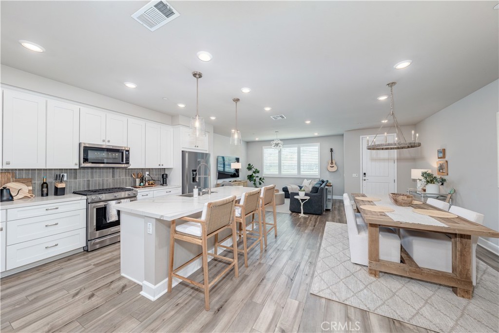 Welcome to the vibrant Regatta community, nestled in the iconic Surf City USA just a short distance to the surf. This home shows like a model home and boast 4 bedrooms & loft. As you step onto the charming front patio, you are immediately greeted by an inviting atmosphere that sets the tone for this exceptional home. Inside, the space showcases stunning engineered hardwood flooring and elegant California shutters, which create a warm and sophisticated ambiance throughout. The open-concept kitchen is a true culinary masterpiece, featuring exquisite quartz countertops, a stylish modern farmhouse sink, and a walk-in pantry that offers abundant storage. With ample cupboard space and a generous island complete with a serve-over bar, this kitchen is designed for both casual gatherings and lively entertaining. Both the dining room and living room are adorned with beautiful chandeliers, adding a touch of elegance to these inviting spaces. The four spacious bedrooms are designed with comfort in mind, each equipped with ceiling fans to keep the atmosphere cool and inviting. Meanwhile, the thoughtfully designed 2.5 bathrooms ensure convenience for both family members and guests. Retreat to the primary suite, a personal haven featuring a large walk-in closet and an en-suite bathroom with dual vanities. Upstairs, discover a versatile loft space that can be tailored to your needs, along with a dedicated laundry room for added convenience. Enjoy leisurely bike rides to a variety of restaurants, shopping destinations, Trader Joe's, Pacific City, Main Street, The Huntington Club, Central Park, wetlands, pristine beaches, and award-winning schools. Experience the best of Southern California living!