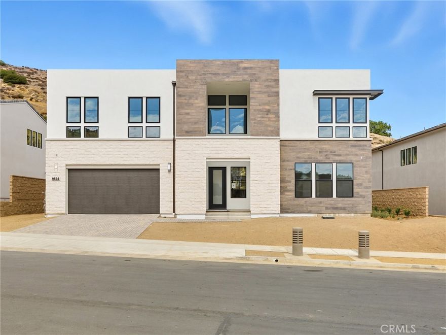 Brand new construction by Toll Brothers-Hidden Oaks, an exclusive community of only 33 luxury estate-sized homes on expansive, equestrian home sites in an established Chatsworth, CA location, surrounded by nature, mountains and boulders, yet so close to everything you love about the city. This Sunstone floor plan is MOVE-IN READY NOW with over $390,000 in designer upgrades, including shower tiling, flooring, cabinet hardware and more! A welcoming covered entry opens onto a soaring two-story foyer with modern glass stair railings, a stunning two-story great room with 78” linear fireplace and 20’ x 8’ multi-slide stacking door and expansive glass windows atop, allowing maximum visibility of the unique boulder mountain backdrop at the end of the nearly 80’ deep expansive rear yard with 12’ wide side yards. Upgraded Alabaster White Craftsman cabinets throughout the home. The expertly designed kitchen features a large center island with waterfall edge and breakfast bar, 2 side-by-side 30” WOLF induction ranges with a wide 60” hood, SubZero refrigerator, plenty of quartz counter space and walk-in pantry at the end of a versatile large flex room. The 12’ x 8’ multi-slide stacking door at the kitchen offers desirable access to the luxurious outdoor living space, where you can look out to an over 22,000 sf home site with approx. 12,250sf net pad. A first-floor bedroom with a private bath and walk-in closet is adjacent to a large flex room/office space. The primary bedroom suite includes a covered deck to enjoy starry nights, expansive walk-in closet and lush primary bath. Secondary bedrooms, each with a generous walk-in closet and full private en-suite bath, are adjacent to a huge loft overlooking the main living area. This home has a 3-car tandem garage, offering ample space for vehicles, hobbies or additional storage. The everyday entry off the garage leads into an extended, functional drop zone. Solar purchase/lease is required. Electrical and low voltage upgrades included. The open and airy floor plan is designed with luxury modern living in mind, ideal for both relaxation and hosting guests. Located within a serene setting, this home provides the perfect balance of comfort with the convenience of nearby shopping and easy access to freeways, entertainment and recreation. This home has been thoughtfully designed throughout with a professional touch by a Toll Brothers designer. *Photos are of the Model Home, not the actual home for sale.