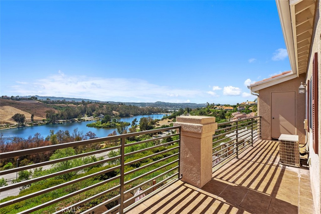 FANTASTIC PANORAMIC LAKE AND CITY LIGHT VIEWS. You'll enjoy coming home to this open floorplan, upgraded two story townhome. As you enter the home the living room and dining room feature tall two story ceilings. The living room has a gas/wood burning fireplace faced with tumbled stone. The dining room has large patio doors leading out onto the amazing patio with forever views. The kitchen has been upgraded with custom tiled counters, stainless appliances and white finished cabinets and a large window overlooking the lake. There are 2 bedrooms located on the first level, Enjoy the views from the primary bedroom with large patio door leading onto the patio, en-suite bathroom has dual sinks, large walk in closet with built-ins and a large shower. 2nd level has the loft/3rd bedroom option with private bath and closet. This is perfect for a 3rd bedroom or office space. Most windows have upgraded wood shutters. Two single car garages with one having direct access. This Costa Brava community is in the Rancho Niguel area of Laguna Niguel and close proximity to Laguna Niguel Lake & Regional Park, Wood Canyon Park. Both offer lots of hiking, biking and walking trails and scenic areas for relaxing. Watch Laguna Niguel's 4th of July celebrations right from your patio. Rancho Niguel also offers its residents membership to "The Club at Rancho Niguel" which has a large gym, pools, tennis basketball and pickleball courts. playground, tot lot, and clubhouse for events. Award winning schools, great dining and shopping opportunities are close by. This is a great place to call home.