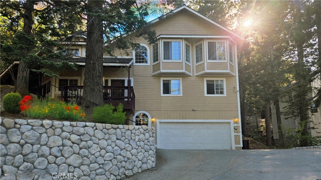 Professional photos coming, but in the meantime, attention all 90s Grandmacore lovers! Welcome to this Lake Arrowhead dollhouse near the golf course, cradled among the trees, where the charm and warmth are reminiscent of a coastal bed-and-breakfast—playful, whimsical, and full of timeless character. The home sits on an upslope lot with gorgeous curb appeal, featuring a covered porch, mature trees, and a gently sloped driveway leading to a deep 2-car garage. Inside, 4 spacious bedrooms and 3 bathrooms invite comfort and relaxation. In addition, theres a bonus room on the main floor that can serve as a dining room, office or den. The sunken living room soars with high ceilings and a dramatic stone wall fireplace, surrounded by layered patterns, textured wood floors, and vintage pendant lighting. Floral wallpaper, Tiffany-style lamps, preserved old tile, and quirky, one-of-a-kind décor create a collected-over-time aesthetic that Grandmacore enthusiasts adore. Every nook—from cozy reading corners to colorful window seats—feels curated, warm, and full of character. Outdoors, a brick patio hugged by mature trees offers a secluded, romantic backdrop for morning coffee or evening entertaining. The property’s warmth, charm, and whimsical personality make it a true mountain retreat. Whether you embrace its vintage details or add your own updates, this one-of-a-kind property captures the magic of Lake Arrowhead living—laid back, collected, and brimming with style.