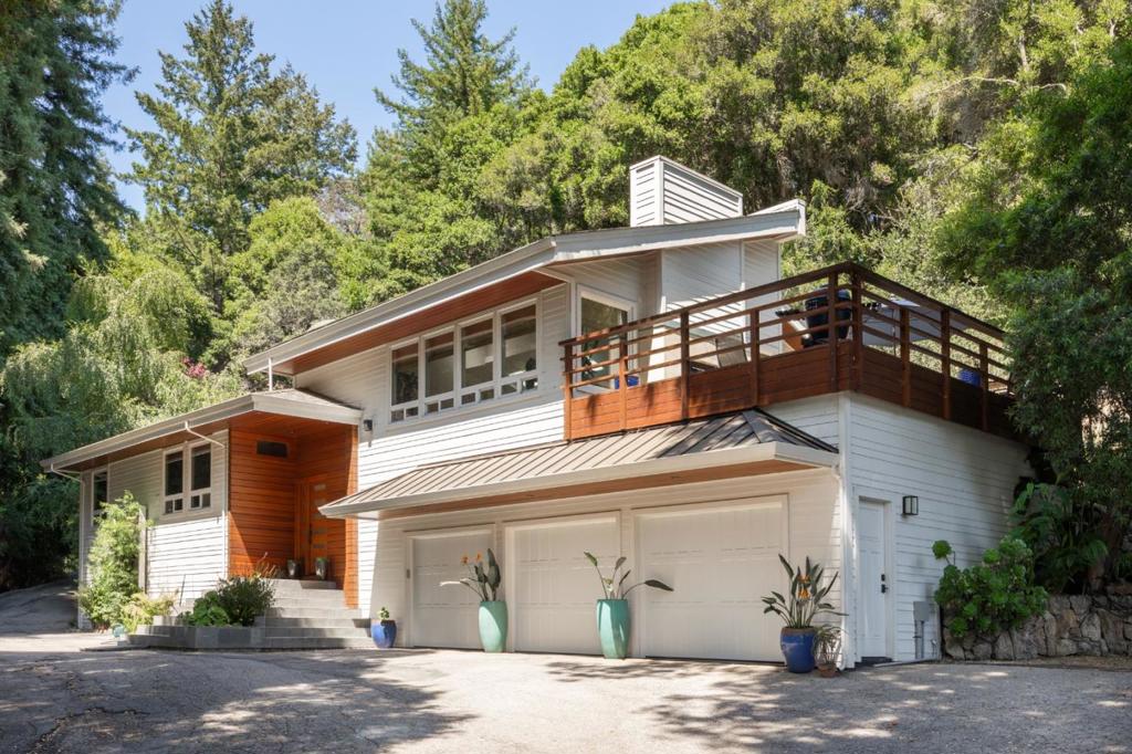 Welcome to this exceptional 3-bedroom, 2.5-bathroom residence nestled in between Santa Cruz and Scotts Valley. Offering over 3,361 sq.ft. of thoughtfully designed living space, a private gate leads to this home that sits on over 3.5 acres of serene land. The gourmet kitchen is a chefs dream, featuring granite countertops, custom cabinetry, a large center island with sink, and high-end appliances. The adjoining dining area, set beneath a skylight in the living room, creates a warm and inviting space for everyday meals or entertaining. This home showcases a beautiful blend of wide plank hardwood, stone, and carpet flooring, all finished to the highest standards. Artisan-crafted woodwork graces every corner of the home, elevating it to a class of its own. The primary bedroom features a huge walk-in closet, soaking tub and walkout access to a jacuzzi tub. The spacious outdoor deck invites both lively gatherings and quiet evenings under the stars, while a soothing rock waterfall and koi pond offer resort-like ambiance. The property also includes a remodeled, detached 2-bedroom guest cottage ideal for visitors or extended family,. A three-car garage adds convenience and plenty of storage. Refined and move-in ready, this Santa Cruz gem combines luxurious comfort with natural beauty.