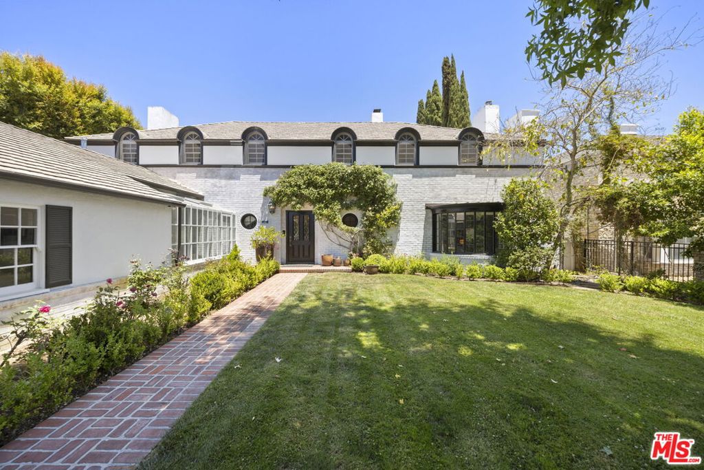 Tucked behind lush landscaping on one of the most coveted and tranquil streets in prestigious Little Holmby, this stately traditional residence immediately enchants with its secluded, picturesque entry. Brimming with mature plantings the front garden offers a serene welcome, a quiet retreat from the city and a charming prelude to the elegance within. Upon entry, the home exudes timeless sophistication, defined by its gracious scale, flowing floorplan, and soaring ceilings, the hallmarks of classic traditional architecture. Every public room on the main level, from the expansive living room with fireplace to the formal dining room and richly paneled library, opens seamlessly to the beautifully landscaped rear gardens, creating a natural indoor-outdoor rhythm ideal for entertaining or gracious daily living. The remodeled chef's kitchen anchors the heart of the home, outfitted with premium appliances, extensive custom cabinetry, peninsula with seating , and thoughtful details that blend modern convenience with enduring charm. Additionally, the main level features a versatile bedroom suite, perfect for guests, staff, or multi-generational living. Upstairs, the oversized primary suite is a peaceful sanctuary with sweeping views, a luxurious bath, multiple closets, and direct access to a spacious balcony. Two additional bedroom suites also open to this balcony, enjoying panoramic vistas of treetops, the LA Country Club, and the Griffith Observatory in the hills beyond, elevating everyday living with a touch of the extraordinary. A fourth full suite, an uncommon feature, completes the upper level of the home. Moving outside, a sparkling pool and spa, designed by Don Burgess, anchors the rear garden. Surrounded by mature trees and with nearly half an acre of land, the property offers ample space for any amenity possible, whether a pickleball court, guest house, or collector car garage any dream can become a reality utilizing the rare street-to-street lot with secondary access from Comstock Avenue. This is a incomparable offering that blends timeless architecture, verdant privacy, and an irreplaceable location. Moments from Holmby Park, UCLA, and the best of Century City, Westwood, and Beverly Hills, yet tucked away in a world all its own this is Little Holmby at its absolute finest.