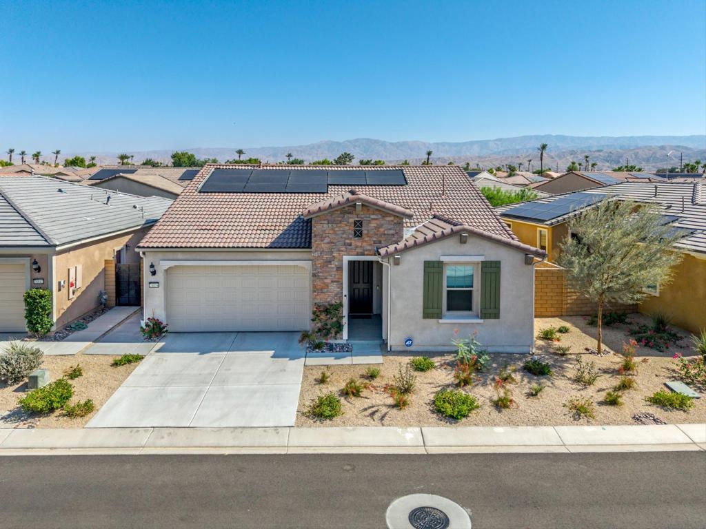Welcome to Domani, a premier 55+ gated community in Palm Desert offering resort-style amenities and a vibrant lifestyle--all with low HOA dues. This highly desirable Bellwood floor plan features three bedrooms, two bathrooms, an open-concept great room, and a spacious primary suite. The home is light and bright, showcasing modern high-end finishes and hard surface flooring throughout. Additional features include quartzite countertops in bathrooms, a water filtration system, solar panels, a tankless water heater, custom window coverings, and a two-car garage. The backyard is designed for relaxation, featuring a covered patio, a Zen garden, and low-maintenance landscaping that includes fruit trees. Offered furnished per inventory, this home is move-in ready. Residents of Domani enjoy access to a 5,300 sq. ft. clubhouse, fitness center, resort-style pool, pickleball, bocce ball courts, dog park, and more--all near shopping, dining, golf, and entertainment. Schedule your appointment today to see this immaculate well cared for home.