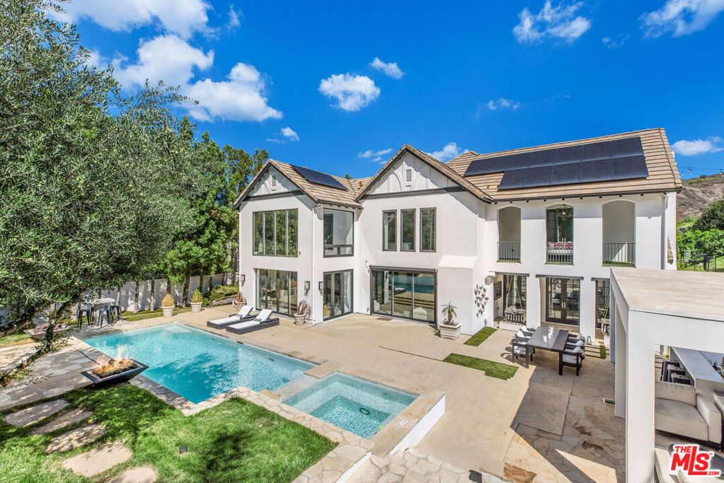 Situated on a coveted corner lot in the exclusive gated community of The Oaks, this stunning estate offers unparalleled privacy and luxury living. Spanning expansive wrap-around acreage, recently updated park-like landscaping and unmatched appeal, the property boasts exceptional outdoor features including a private sport court and a resort-style pool and spa. The outdoor entertaining area includes a covered lounge with a BBQ bar, as well as elevated hillside seating areas, offering a secluded retreat perfect for relaxation and entertaining. Inside, the home exudes stylish sophistication with a modern artistic flair. The expansive family room features a custom modern fireplace and seamlessly flows into a state-of-the-art kitchen, complete with a waterfall stone island bar and striking backsplash. A custom-designed entertaining bar lounge and tasting area further enhance the home's appeal for hosting. A thoughtfully designed kids' lounge is equipped with a fridge, play area, storage, and entertainment space, providing the perfect environment for family living. The lower level also includes a private-entry en suite bedroom, ideal for guests or extended family.The home's state-of-the-art theater room offers a custom cinematic experience, while the second level features four beautifully designed en suite bedrooms, each with unique styling. A cozy living room lounge and a private gym with floor-to-ceiling windows overlooking lush greenery add to the estate's appeal. The primary suite is a luxurious retreat, featuring a custom walk-in closet with accent lighting and a spa-like bathroom with double vanities, an oversized shower, a walk-in dry sauna, and a private glam space. This modern hideaway embodies sophistication and comfort, offering a rare opportunity to experience life in one of Calabasas' most sought-after neighborhoods.With exceptional amenities, ultimate privacy, and breathtaking views, this estate truly redefines luxury living behind the prestigious guard gates at The Oaks.