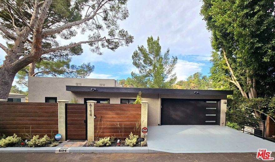 Nestled above the iconic Beachwood Canyon and Hollywoodland, 6194 Rodgerton Drive is a beautifully remodeled, move-in-ready mid-century retreat built in 1965. Thoughtfully updated from top to bottom, this 1,616 sq. ft. two-level home blends timeless architecture with modern comfort and sophistication. Featuring 3 spacious bedrooms and 2.5 bathrooms, the residence offers bright, airy living spaces framed by sweeping canyon, city, and treetop views. Multiple decks and balconies invite you to enjoy LA's legendary sunsets and peaceful hillside ambiance. The cozy living room is anchored by a remote-controlled gas fireplace, while the dining area is surrounded by picture windows that create a stunning backdrop for everyday living and entertaining. The expansive primary suite serves as a private sanctuary, complete with a walk-in closet and a spa-inspired ensuite bath featuring a double vanity and heated flooring. This home has been extensively modernized, making it truly turnkey. High-end upgrades include: New windows and sliding doors, New double entry doors, New insulated garage door, Fully remodeled kitchen with Cafe appliances, Updated bathrooms, New flooring throughout, Brilliant smart home system, Ring cameras and alarm system, and so much more. Every detail has been curated to enhance comfort, style, and everyday ease. An attached two-car garage plus driveway offers generous parking options. Unlock even greater potential with the unfinished lower level, ideal for conversion into additional living space or a possible ADU (buyer to verify). As-built plans, feasibility study, and preliminary design concepts for finishing the space are available upon request. Buyers may also explore the possibility of adding a rooftop deck with Hollywood Sign and city views (buyer to verify). Set in the sought-after Beachwood Canyon community, the home offers a serene, nature-inspired setting perfect for creatives and professionals seeking a peaceful escape. Yet it remains moments from LA's world-class amenities, including Griffith Park hiking trails, the Hollywood Reservoir, and the Hollywood Sign.Remodeled, upgraded, and move-in ready, this home invites you to settle in and start living the quintessential Los Angeles hillside lifestyle. Welcome home! Listing agent has a partial ownership in the property.