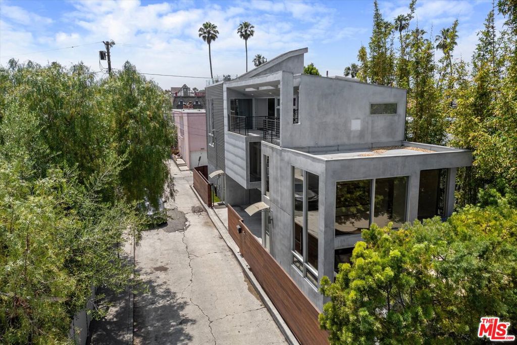 Situated just steps away from the historic Venice Canals, this architectural home features soaring ceilings, walls of glass, and a truly special primary suite. Fully gated for ultimate privacy, this residence is highlighted by a flexible floor plan that can be configured to suite your lifestyle. The front patio seamlessly connects through large sliding glass doors into the sun drenched living and dining rooms that feature vaulted ceilings. Stylish hardwood floors lead you past the two guest rooms and a Jack and Jill bathroom to the West facing kitchen and family room. Flooded with natural light, the spectacular kitchen is punctuated by Italian marble countertops, custom cabinetry, and high end appliances. Perfectly suited for entertaining, the kitchen blends with the family room for that "great room" space while voluminous ceilings and custom built-ins a create grand feeling. Upstairs the third level is wholly reserved for the jaw dropping primary suite. Sliding glass doors take you out to a private balcony where cool ocean breezes flow past the walk in closet to the enormous, recently remodeled ensuite bathroom that features a dual vanity, separate shower and massive tub. The final level of the home is an awesome rooftop deck with views of the Canals and is the ideal setting to take in Sunsets. This home also features a flex space that could be used as gym, office, or game room. This unique home is a sanctuary in the city while also being centrally located near the beach, Abbot Kinney, and Marina Del Rey. Don't miss out on the special lifestyle this home affords!