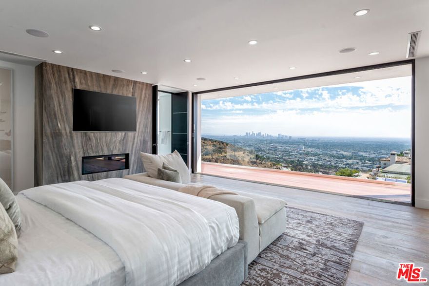 Situated atop Mount Olympus in the Heart of Hollywood Hills this Modern luxury newly built Masterpiece displays extraordinary jetliner views from Downtown Los Angeles to Century City, Catalina Island and beyond. Great for entertaining open floor plan w/ cinema, living, dining, family area all with Floor-to-ceiling fleetwood glass doors to enjoy the panoramic views, & the indoor outdoor entertaining. The private oasis back yard consist of a spectacular infinity pool and spa both overlooking the city of Angels. Master chef's kitchen w/ center island w/ calacatta marble & state of the art appliances. The second floor features three bedroom suites including a master suite with incredible dual walk-in closet, romantic fireplace, a spa-like master bath with bathtub overlooking the breathtaking views of city lights. An expansive rooftop terrace where guests can lounge at the built-in bar. Automated smart home with 2-car garage. Enjoy this one of a kind dream homes & Hollywood Hills Lifestyle!
