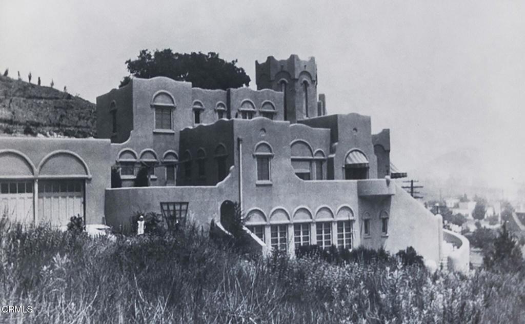 This is a rare opportunity to own one of Glendale's most prestigious homes - a Moorish castle built in 1927! As you approach the graceful private drive, you will notice the John D. Perkins House exhibits many details of Spanish Colonial Revival architecture, particularly its Moorish elements, but there is also a hint of the then-popular but rare Art Nouveau style, especially evident in the curvilinear shapes of the oversized windows. Upon entry, you are immediately drawn to its fabulous design with generous entertaining rooms and hand stenciled archways. The opulent living room with fireplace has grand windows offering lush views of verdant trees beyond. The dining room is open to the kitchen again showcasing beautiful windows and verdant views. The expansive chef's kitchen complete with a butler's pantry with stained glass door, Wolf/SubZero stainless steel appliances, oversized island and adjacent office effortlessly combine modern convenience with timeless sophistication. The graceful wrought-iron curved 'castle like' stairway, with original textural paint, leads up to lavish bedrooms, each meticulously restored to offer modern luxuries while preserving its classic charm. On the lower level, discover an entertainer's paradise with a spacious media room with abundant french windows, a home gym and a charming new bathroom. Don't miss near to the kitchen, a cozy and romantic, patio perfect for entertaining or relaxing after a long day. This home is more than a residence, it celebrates historic elegance and modern luxury, set in the coveted Verdugo Woodlandsl!