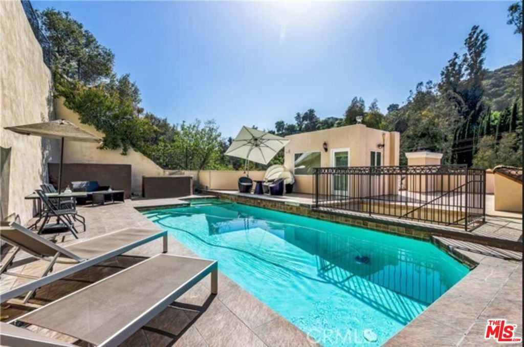 Available now is this spacious and luxurious 3,700+ square foot, 4-bedroom, 4-bathroom house on Benedict Canyon in prestigious Beverly Hills. The formal entry welcomes you with marble and stone floors, leading into a spacious interior featuring high ceilings, abundant natural light, and a cozy double-sided fireplace. The gourmet kitchen boasts stainless steel appliances, ideal for culinary enthusiasts, while the hardwood-floored bedrooms provide a warm and inviting retreat. The rooftop pool and spa create a serene oasis great for entertaining, complemented by central AC and heat throughout the home. A separate ground-floor bedroom adds privacy and flexibility. With four dedicated parking spaces and a prime location just minutes from Beverly Hills' premier shopping and dining. contact us today for a private viewing.